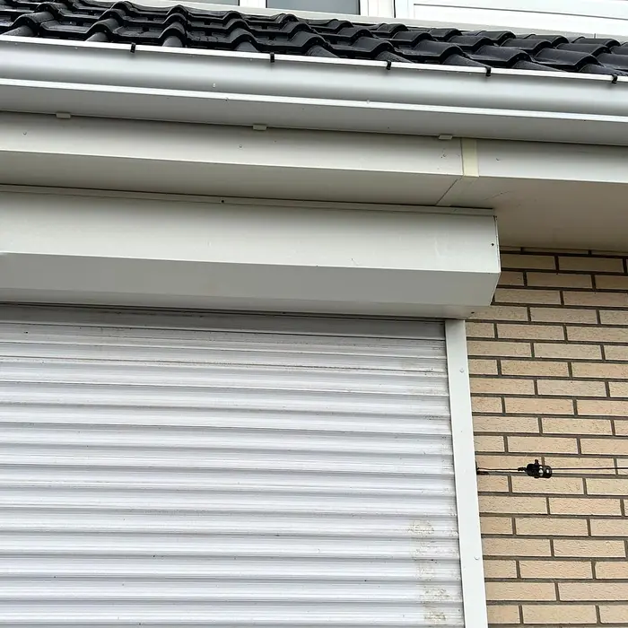 White roller shutter closed over a window