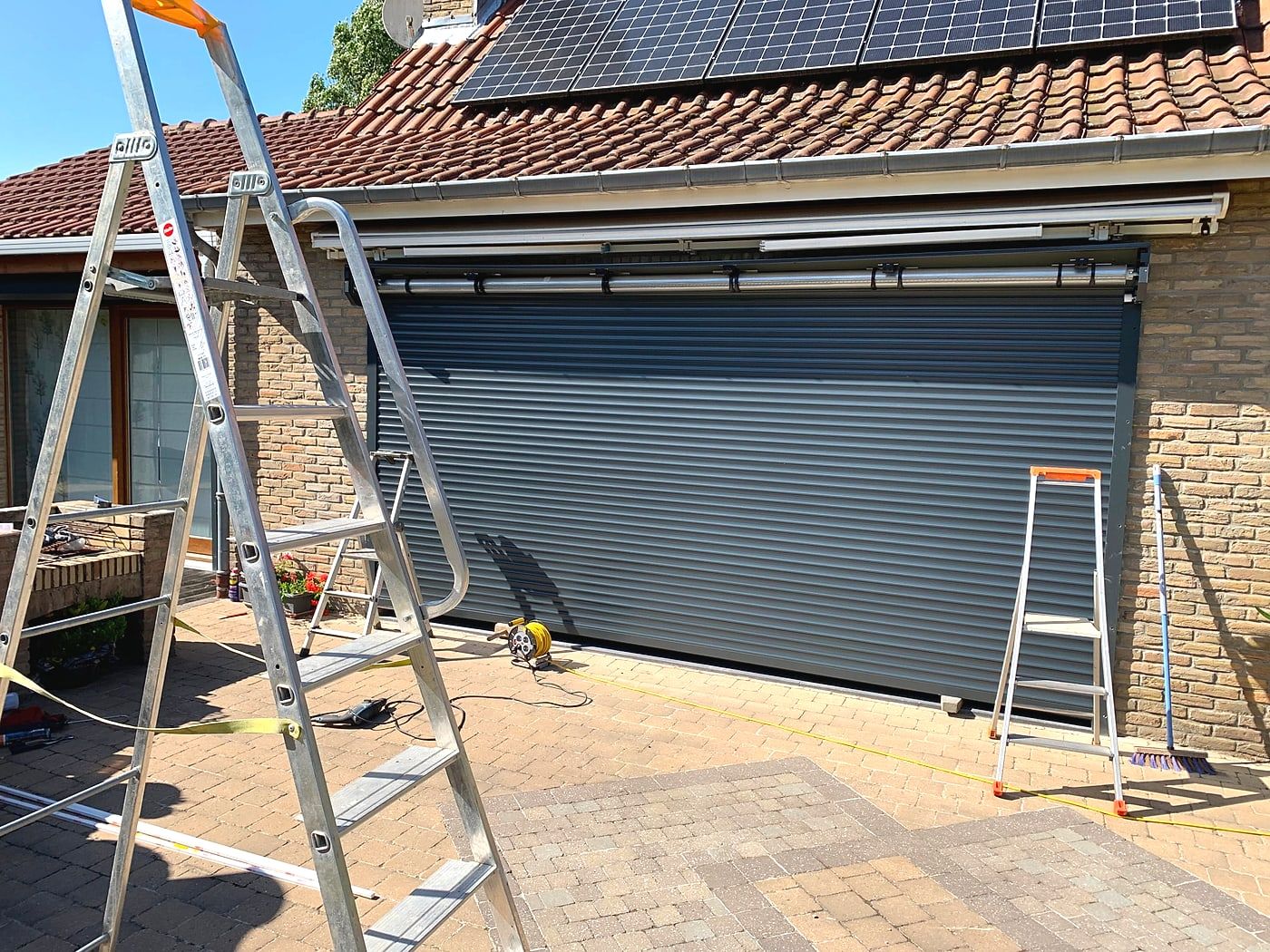 Wide roller shutter being fitted, ladder in place