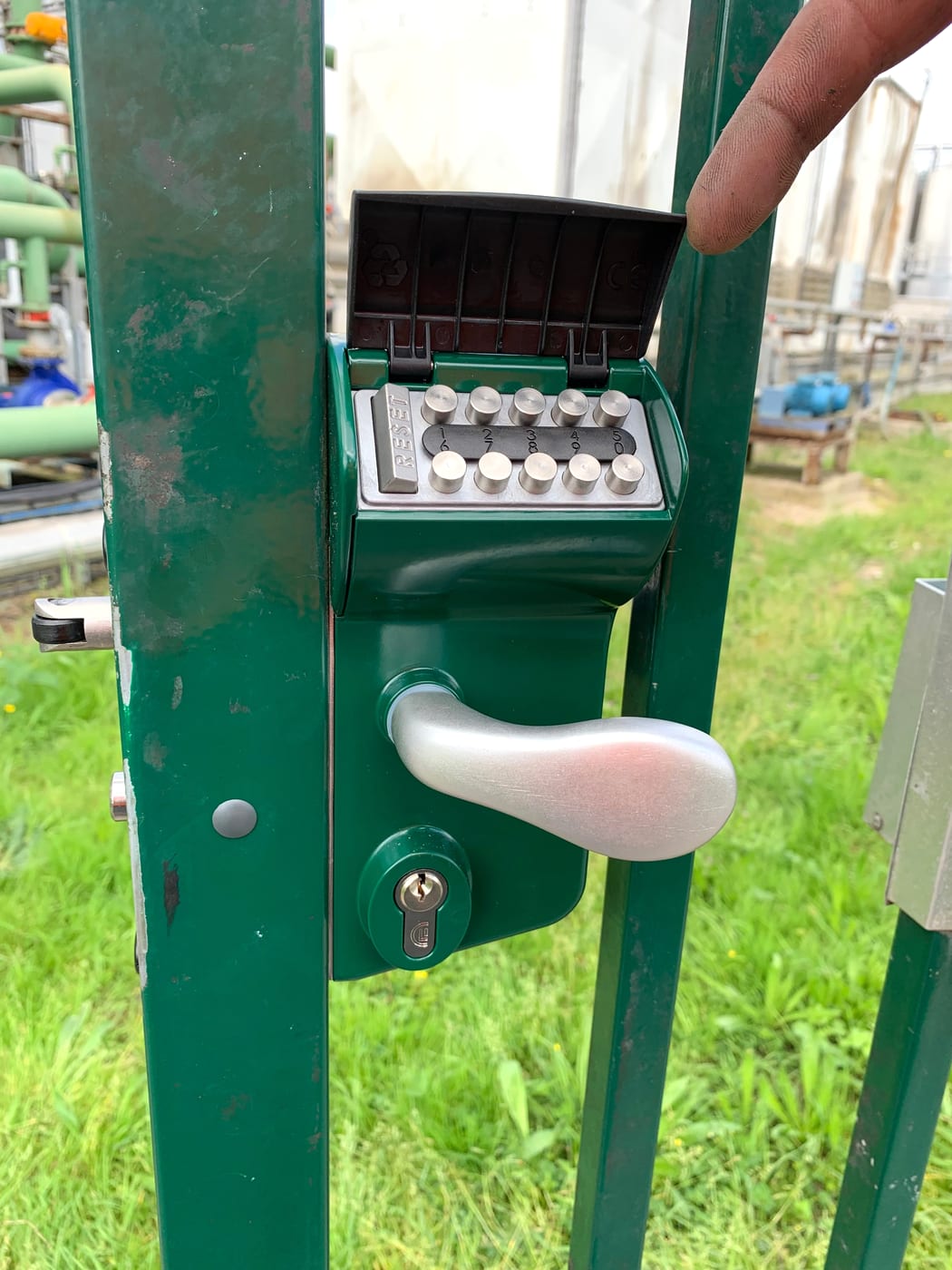 Keypad unit on a green metal gate, outdoors