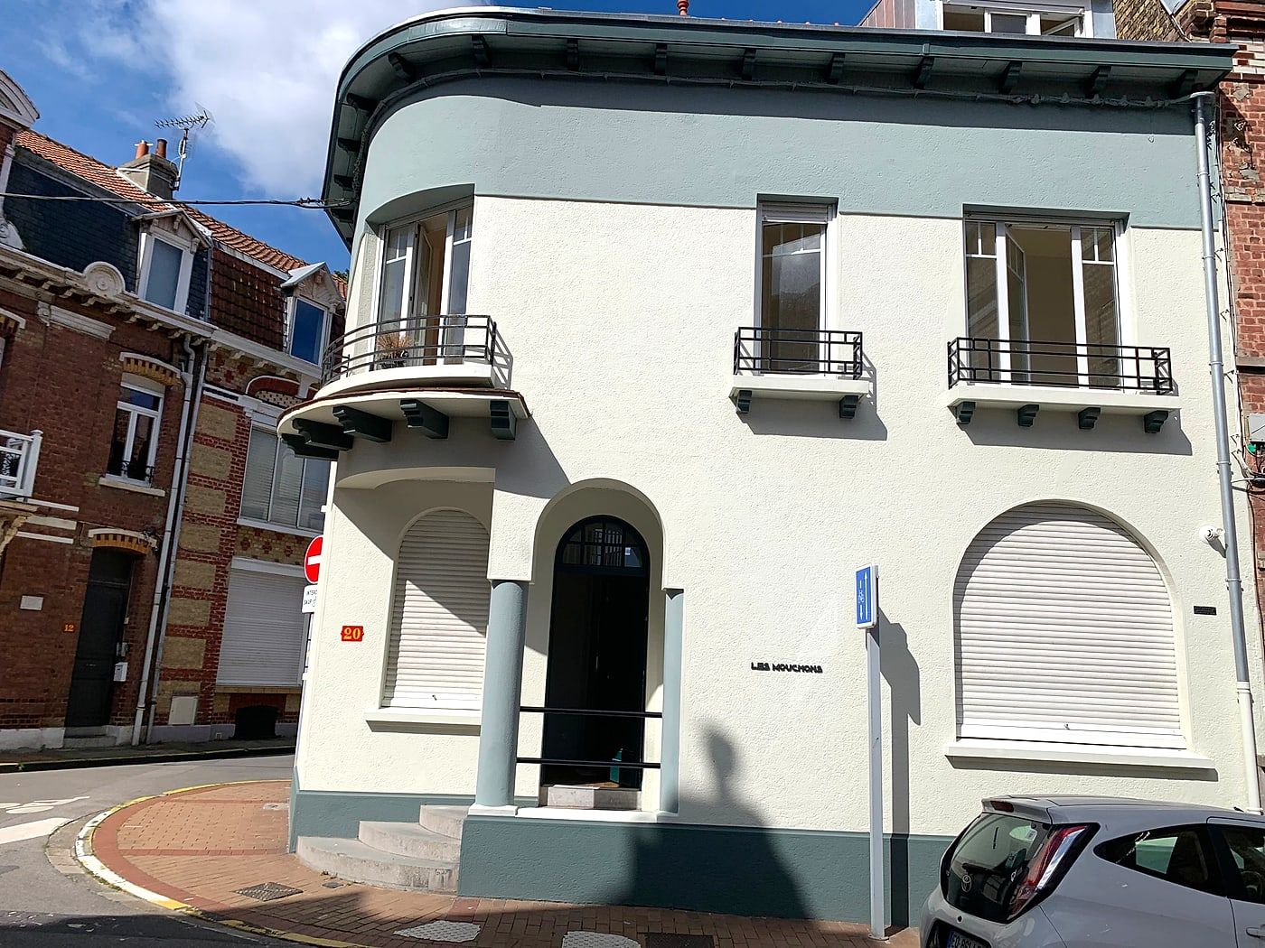 Light-coloured town house with its windows and roller shutters