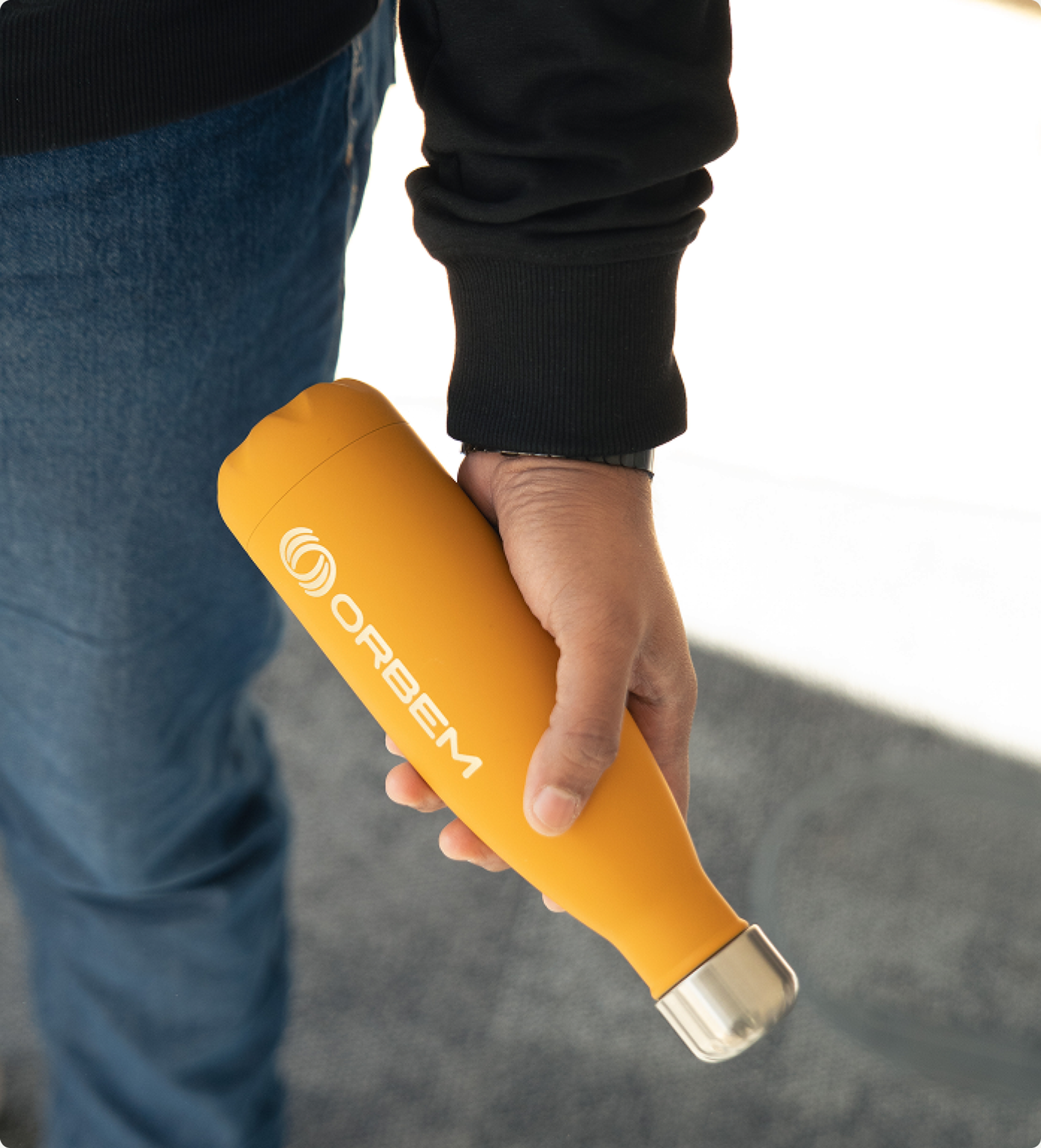 Yellow Orbem water bottle held at a person's side