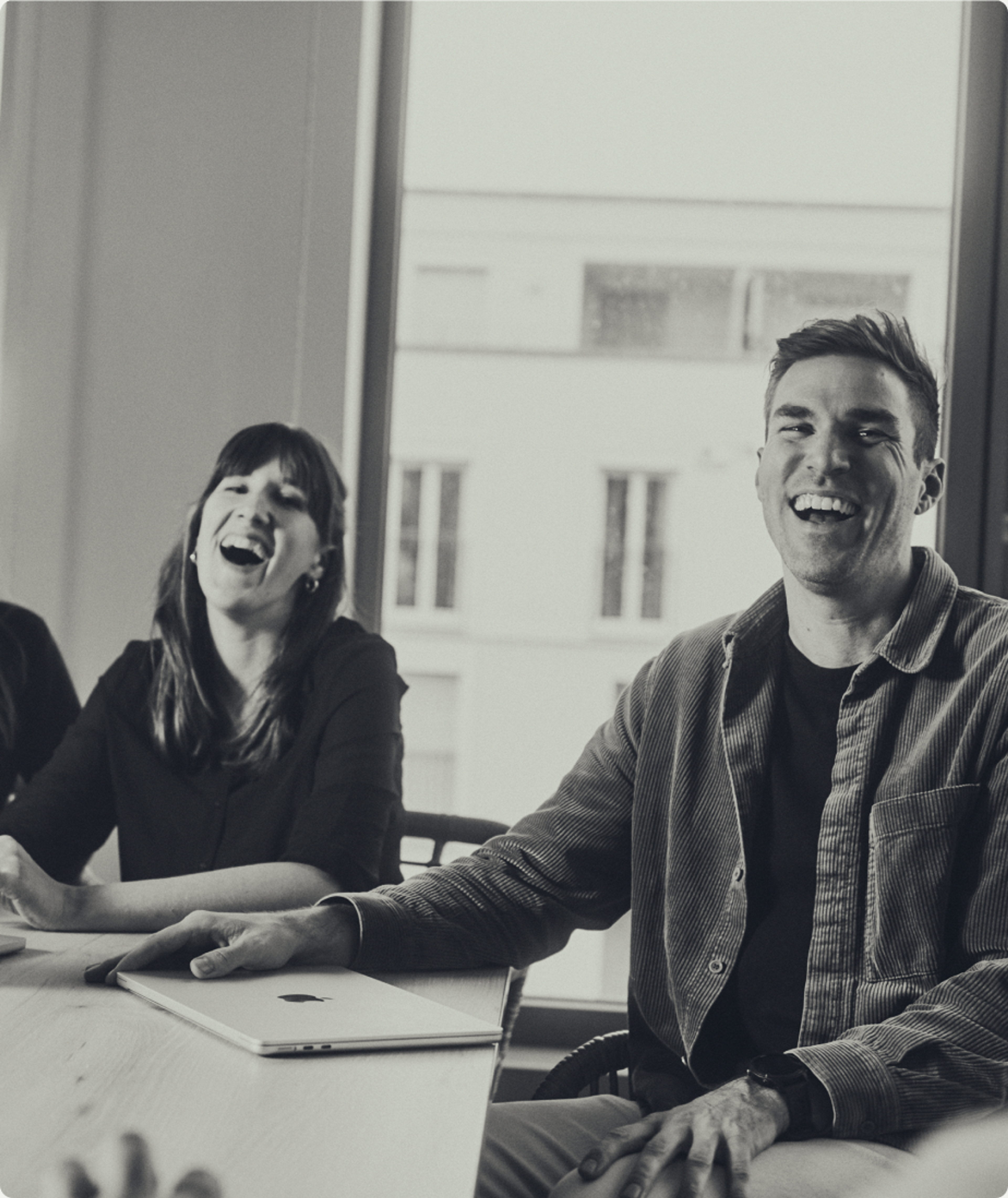 Two members of the Orbem team laughing in a meeting