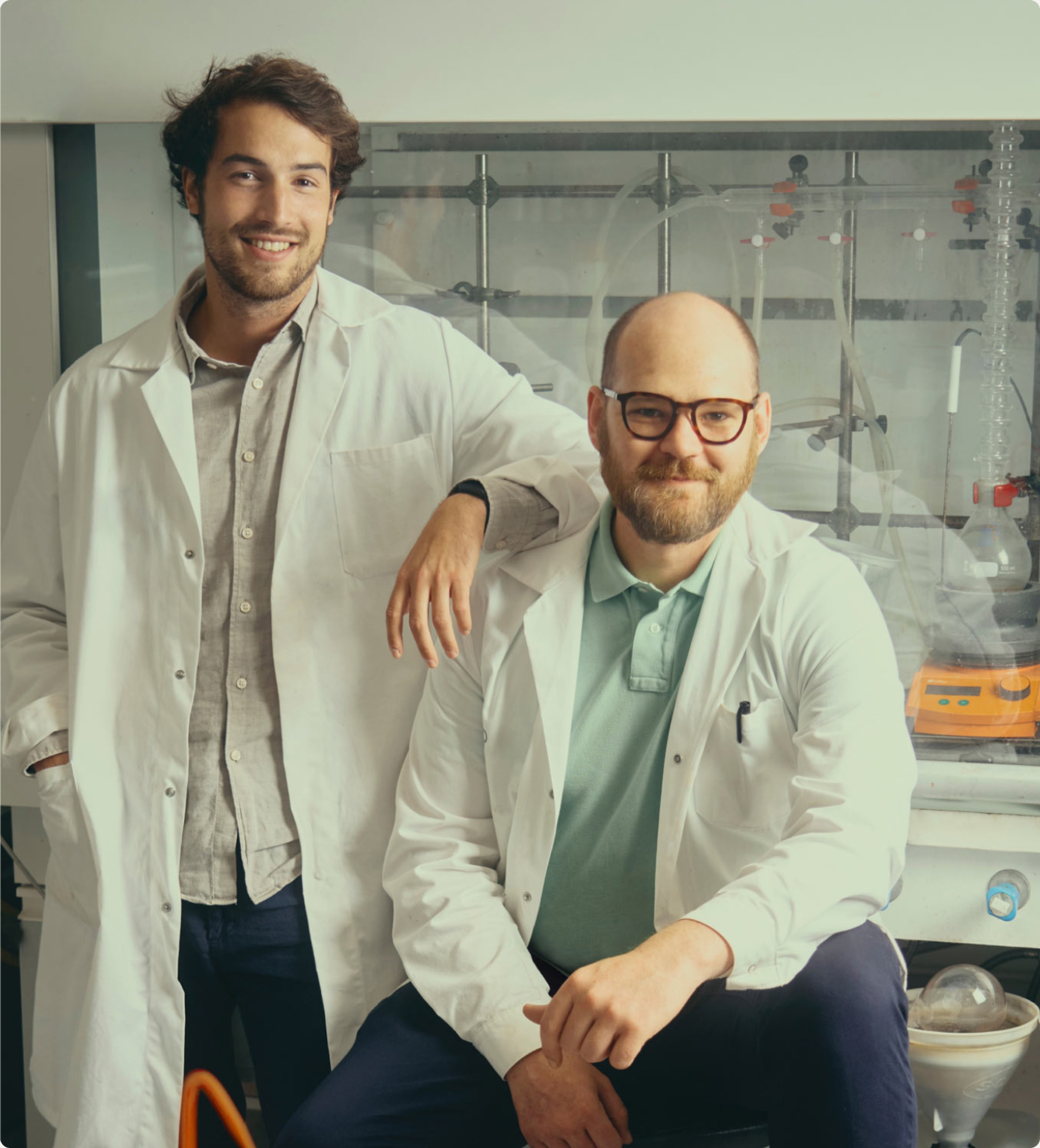 Marco and Louis in white lab coats in the Syntetica lab