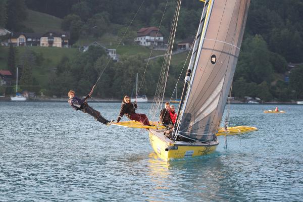 Die Mr. Cello Due im Gegenlicht des Sonnenaufgangs, die Crew auf der Bordwand