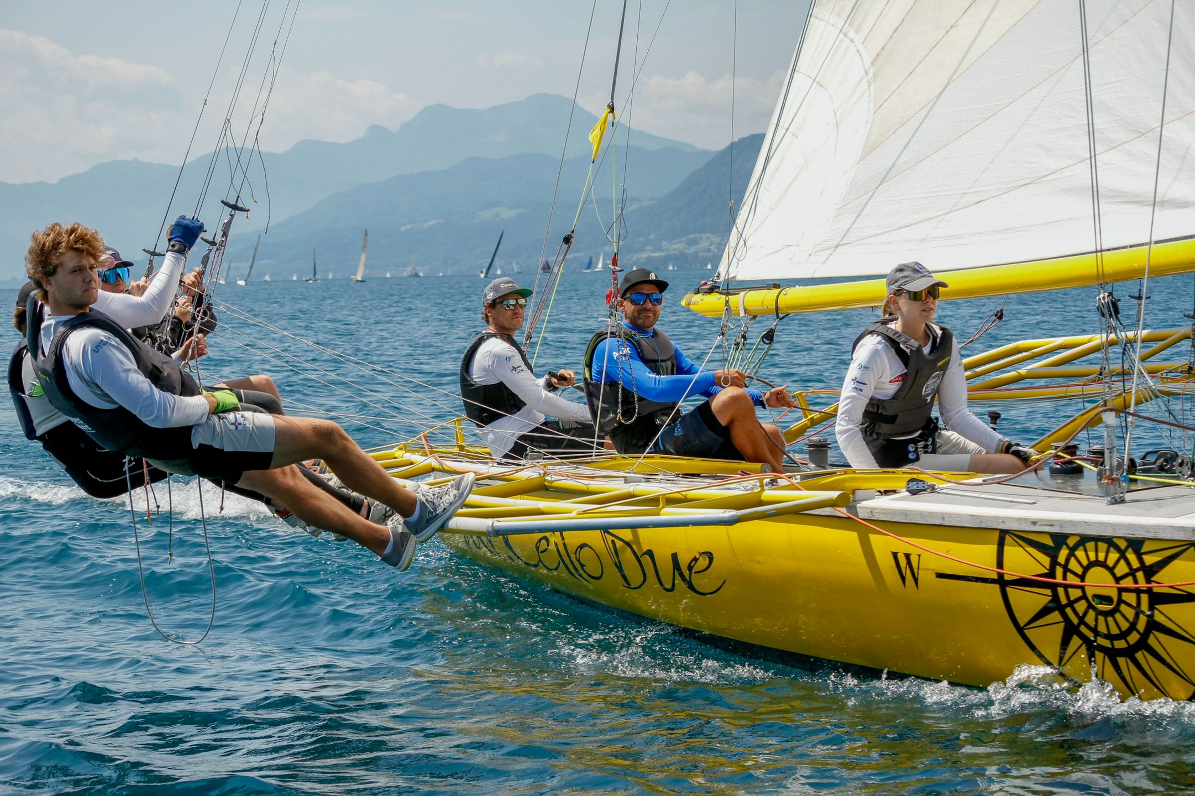 Vier Crewmitglieder am Ausreiten auf dem gelben Ausleger der Mr. Cello Due