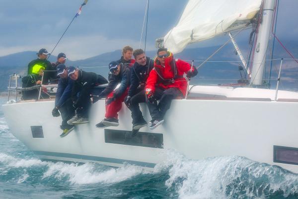 Die Crew am Ausreiten über der Bordwand, Gischt am Rumpf, vor der kroatischen Küste