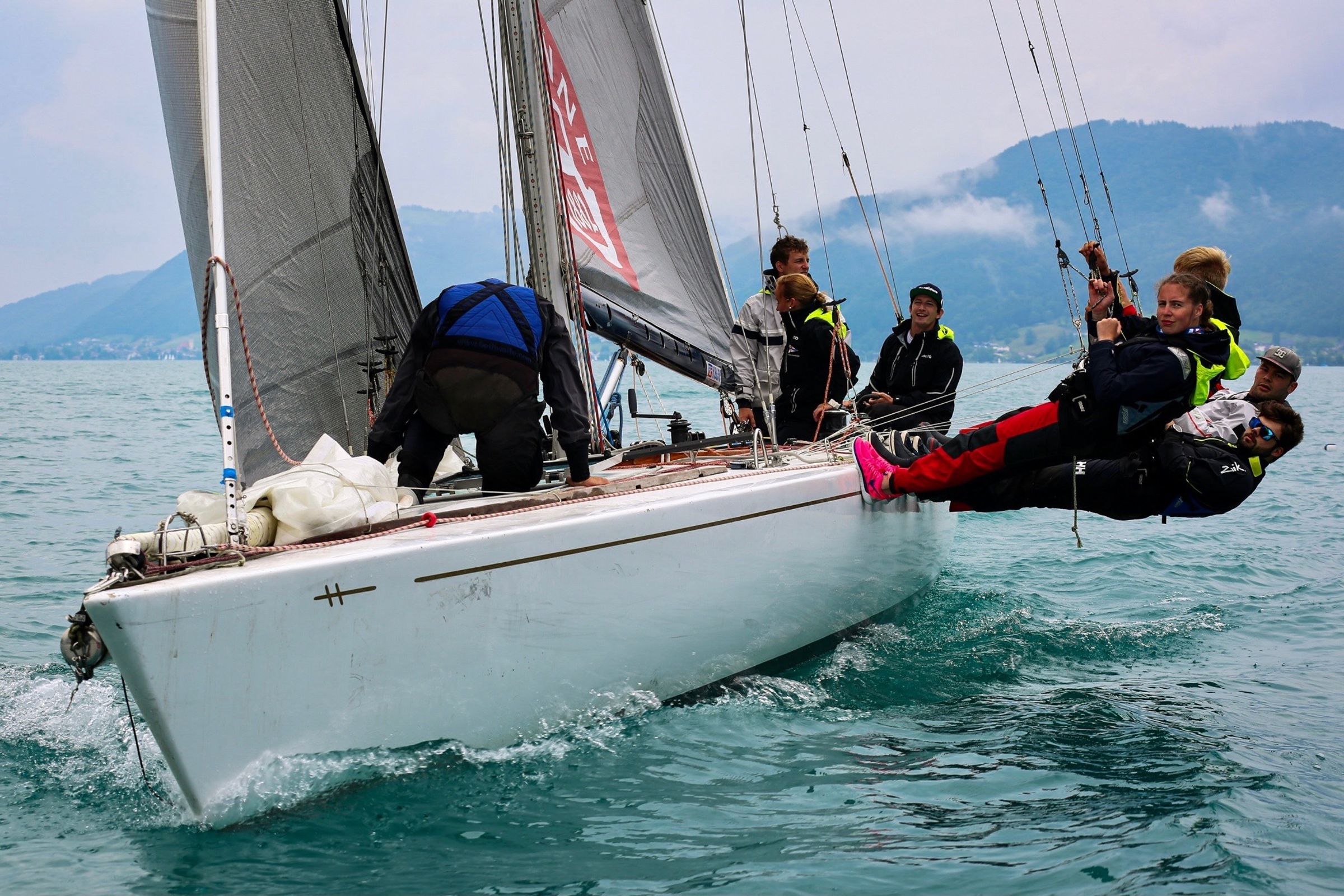 Several crew members far outboard over the rail, the boat hard on the wind