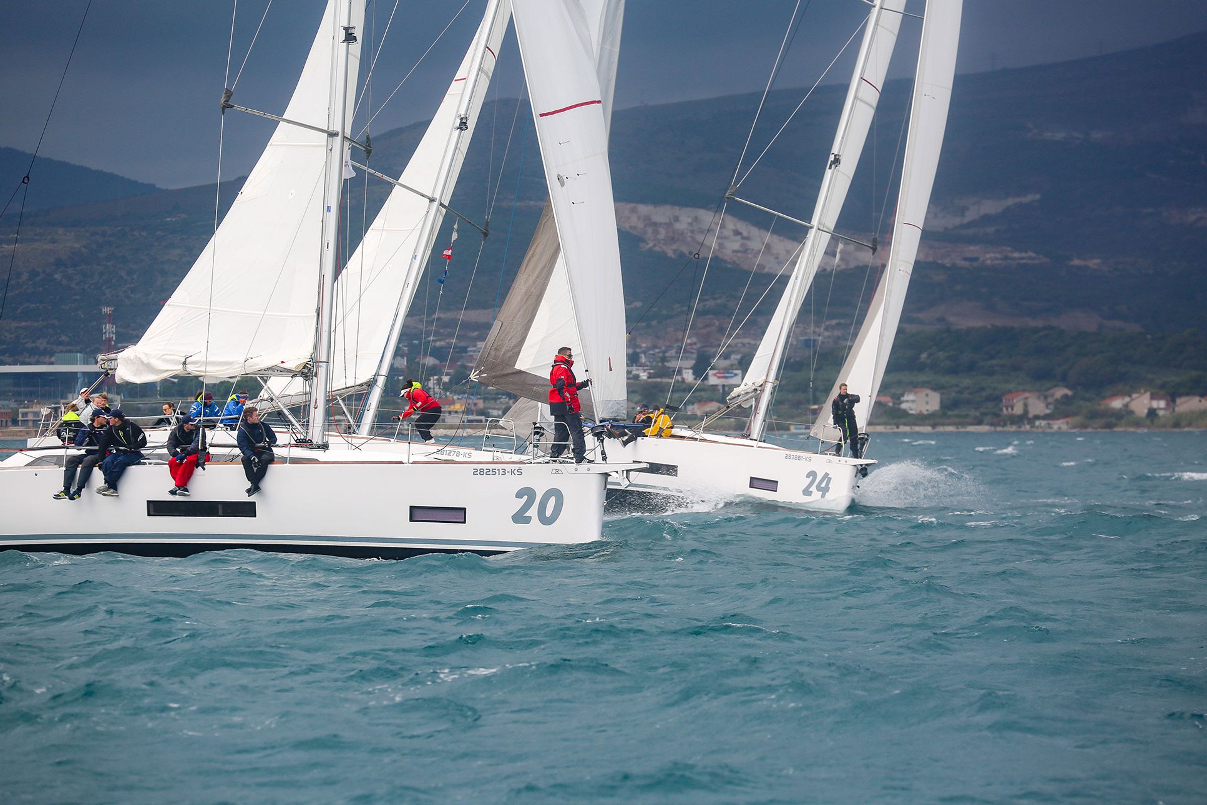 Two identical yachts side by side on the course, bow numbers 20 and 24