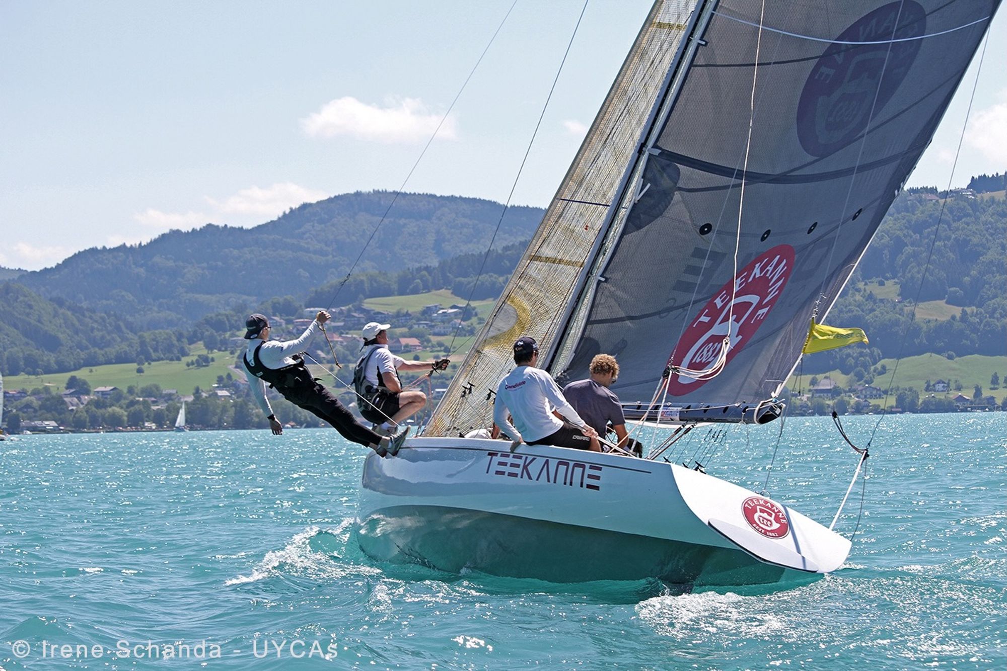 The boat close-hauled below the slopes around Lake Attersee, Teekanne lettering on the hull