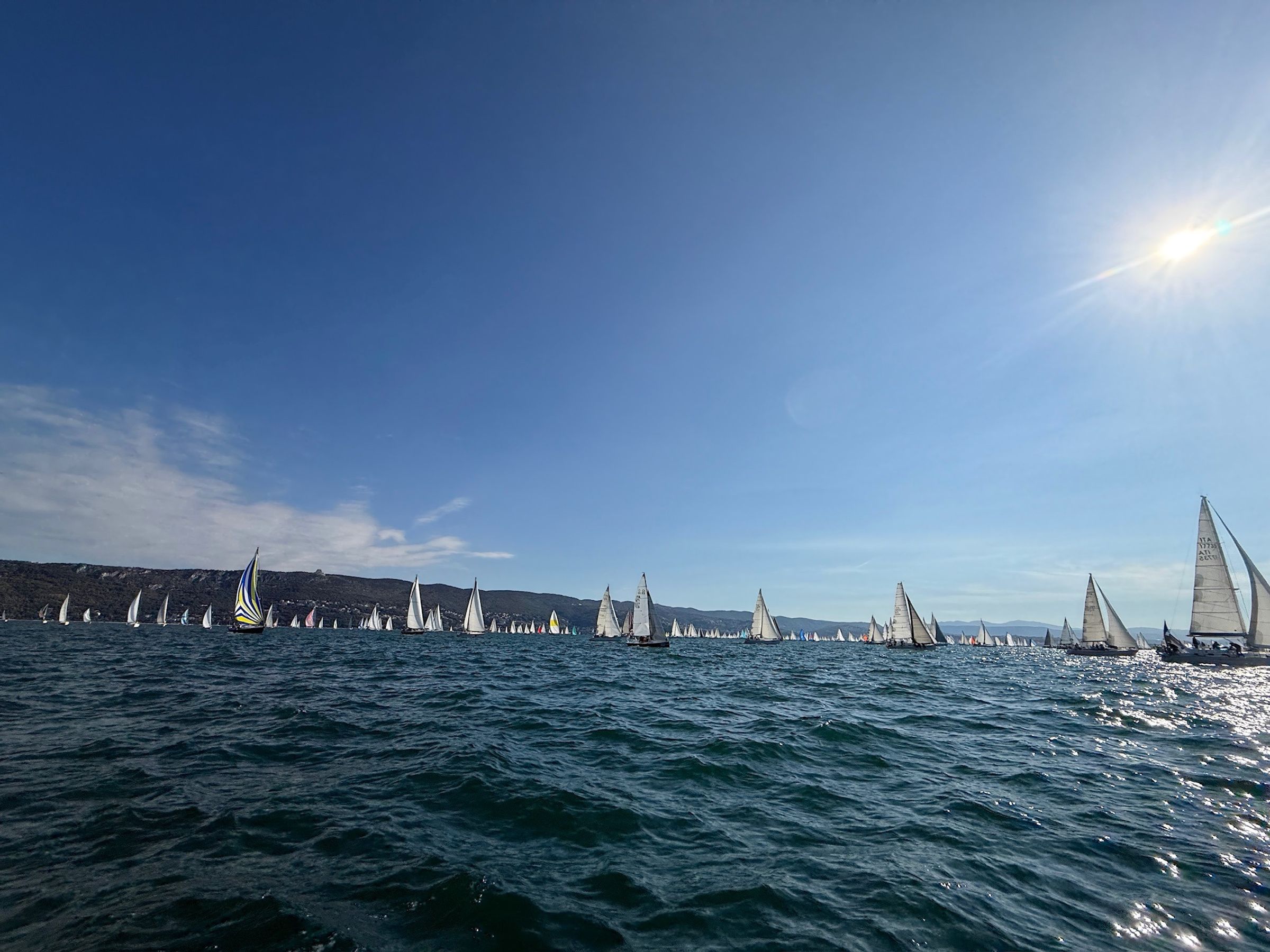 The Barcolana fleet against the light, boats to the horizon