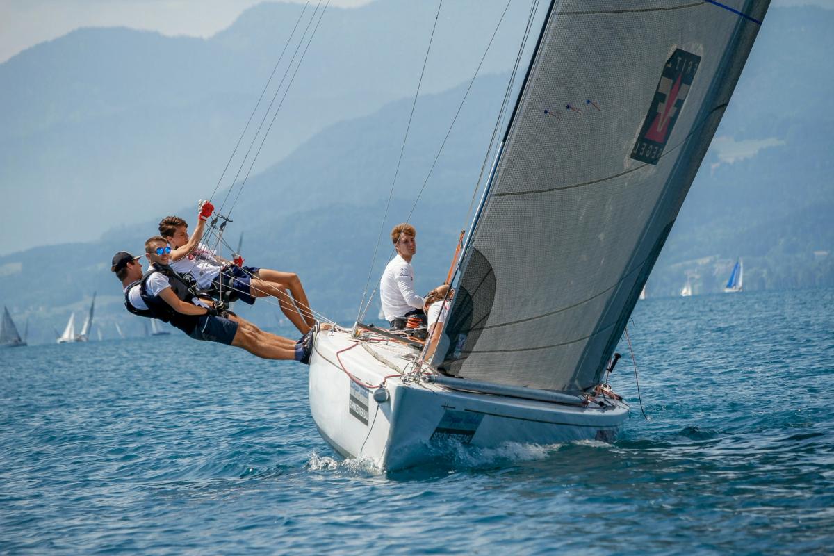 Liberté beating upwind, three crew hiking far out over the rail
