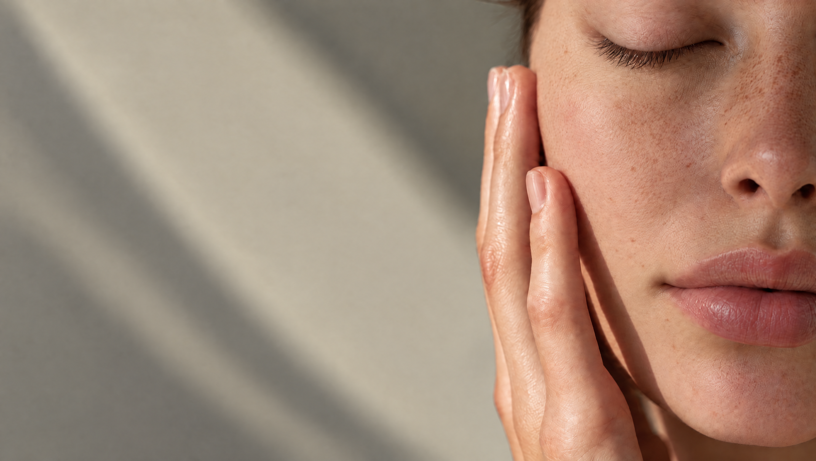 Woman with clear skin resting her hand on her cheek