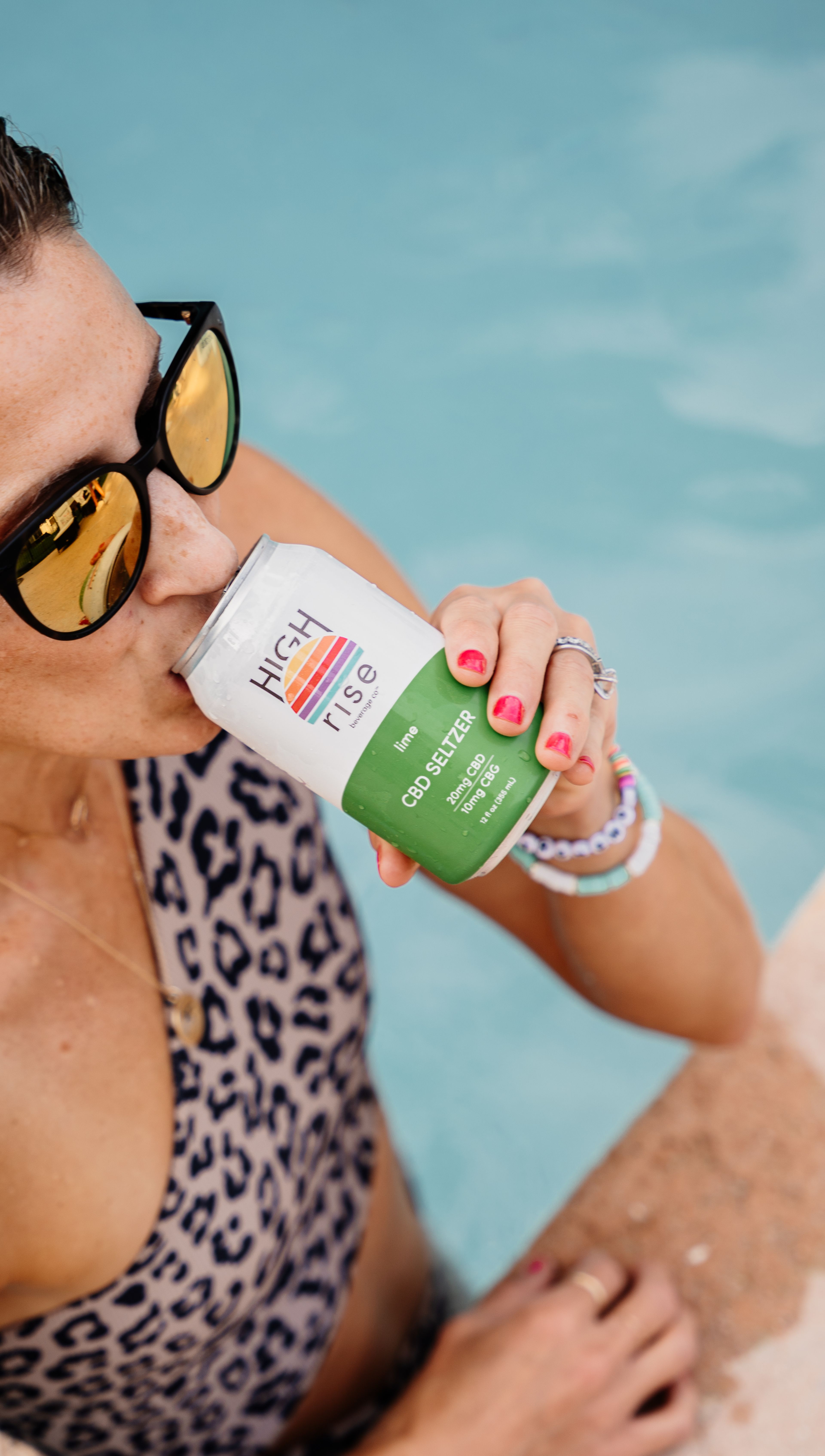 woman drinking lime High Rise CBD seltzer in the pool