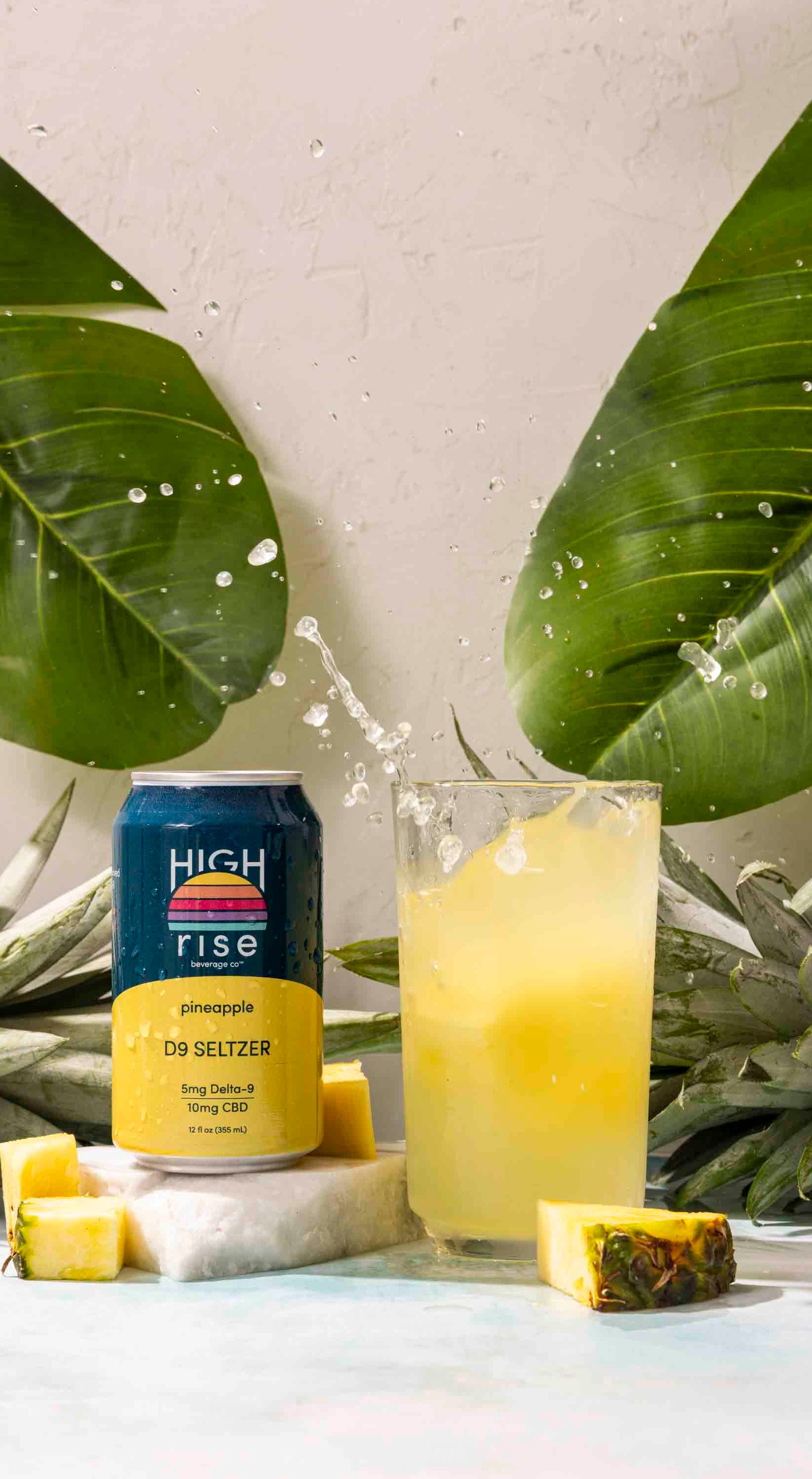 pineapple high rise seltzer splashing into a glass