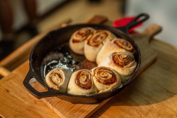 Cinnamon rolls in a cast-iron skillet on the kitchen counter.