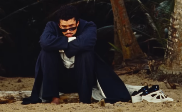 Bad Bunny sitting next to his adidas BadBo 1.0 sneaker