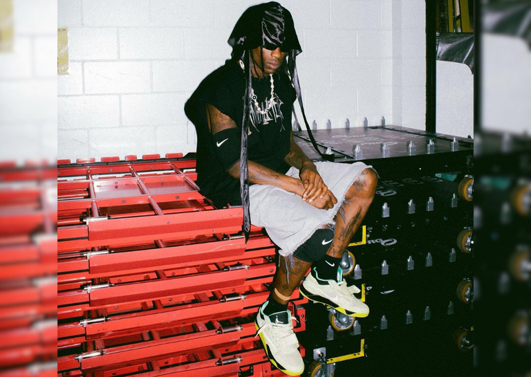 Travis sitting on stage structures in a pair of Jumpman jacks