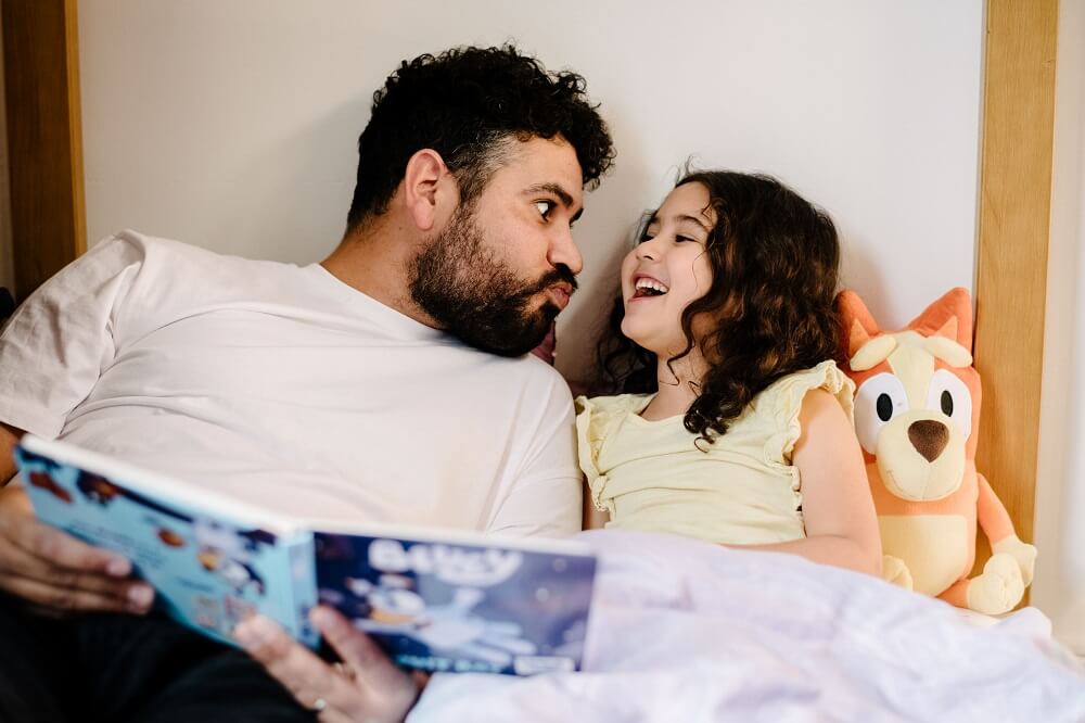 Dad reading a bedtime story to his daughter 