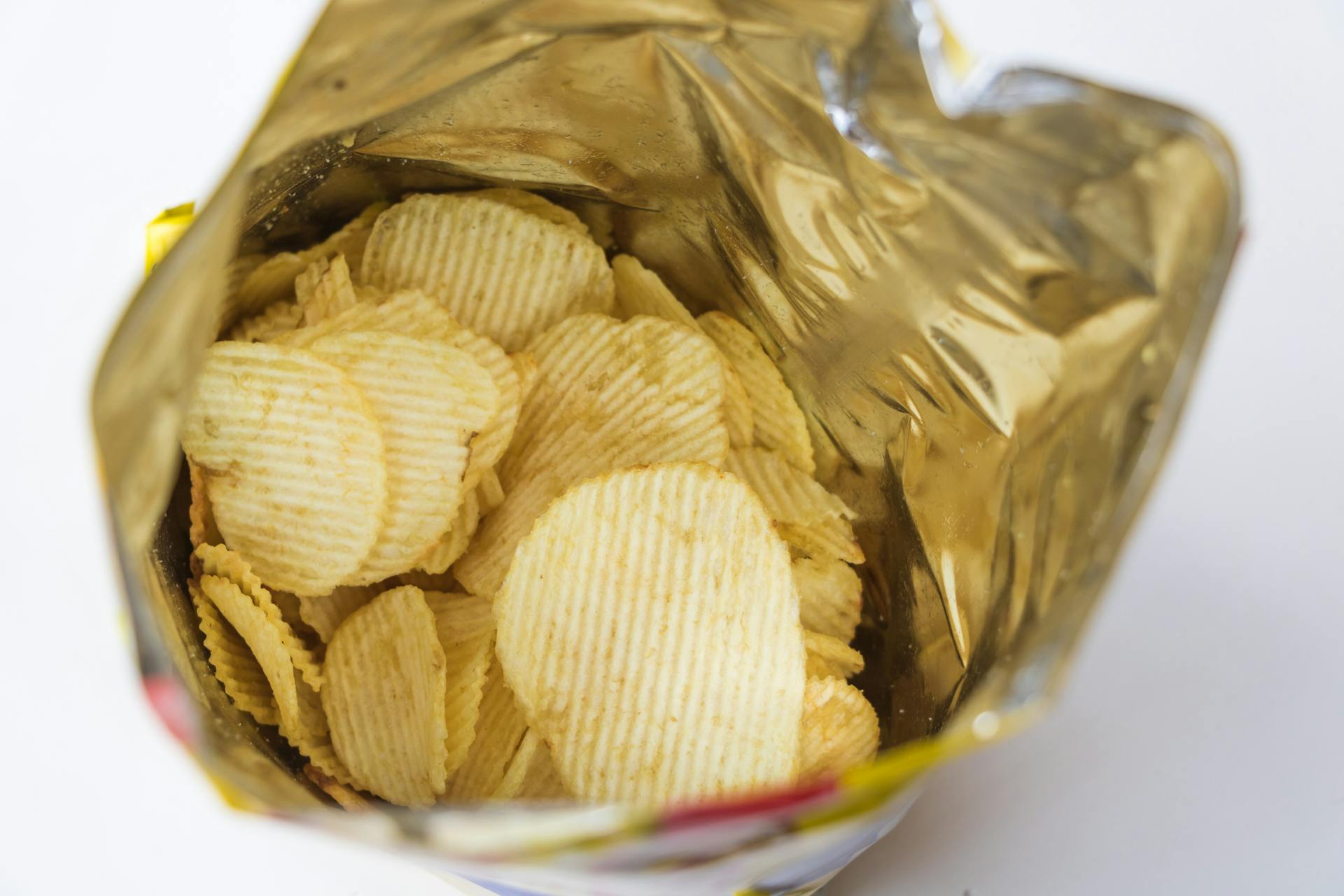 Open bag of ridge-cut potato chips showing surface colour and shape variation