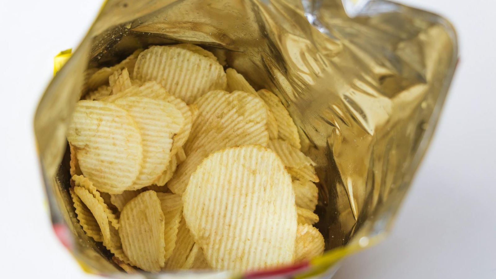 Open bag of ridge-cut potato chips showing surface colour and shape variation