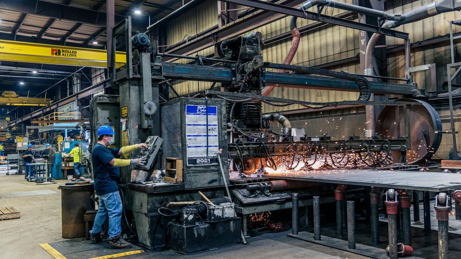 Bediener neben einer Schraubenfertigungsmaschine in der Halle