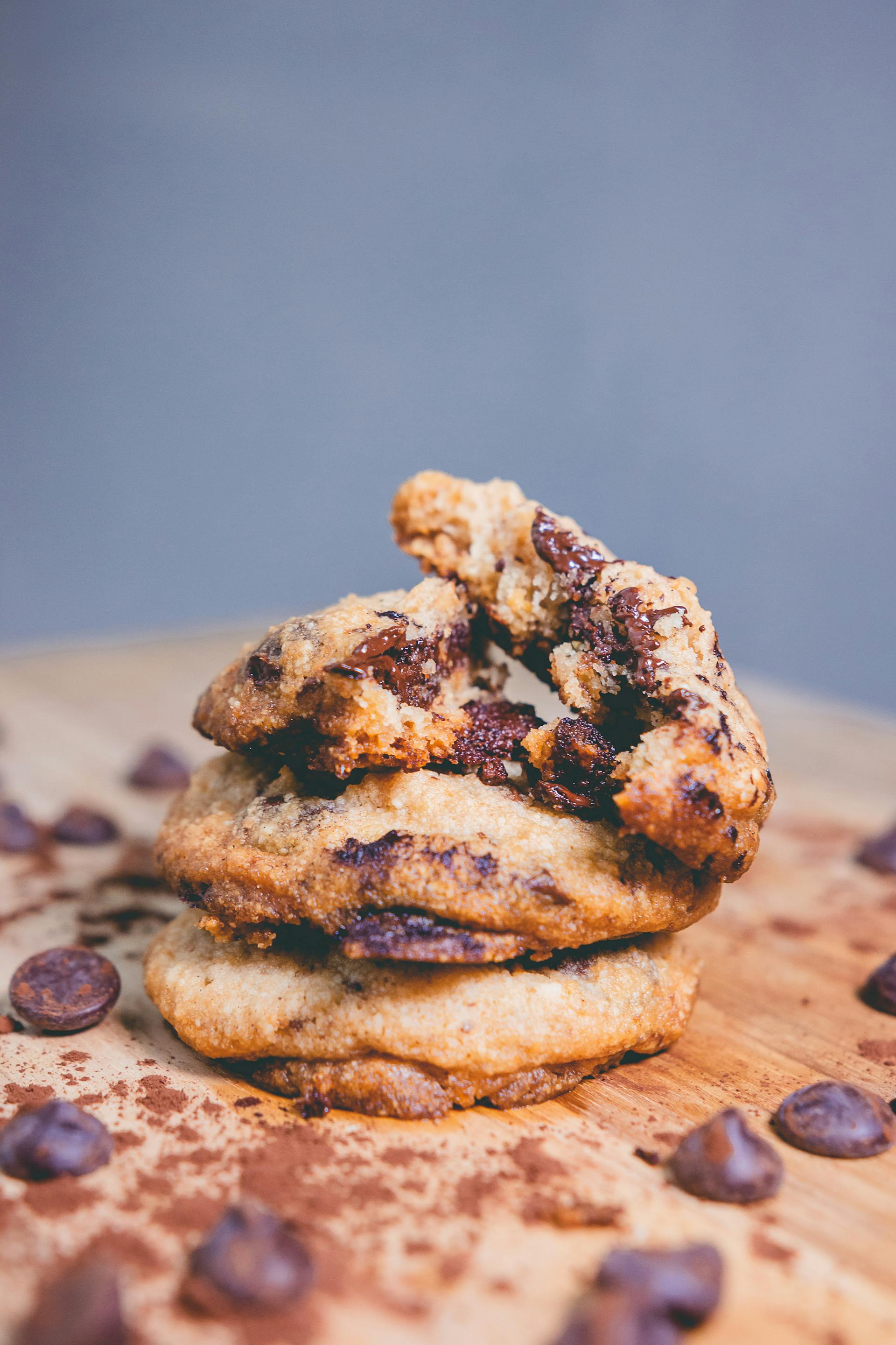Close-up pile of chocolate chip cookies showing surface bake colour, chip distribution, and shape variation