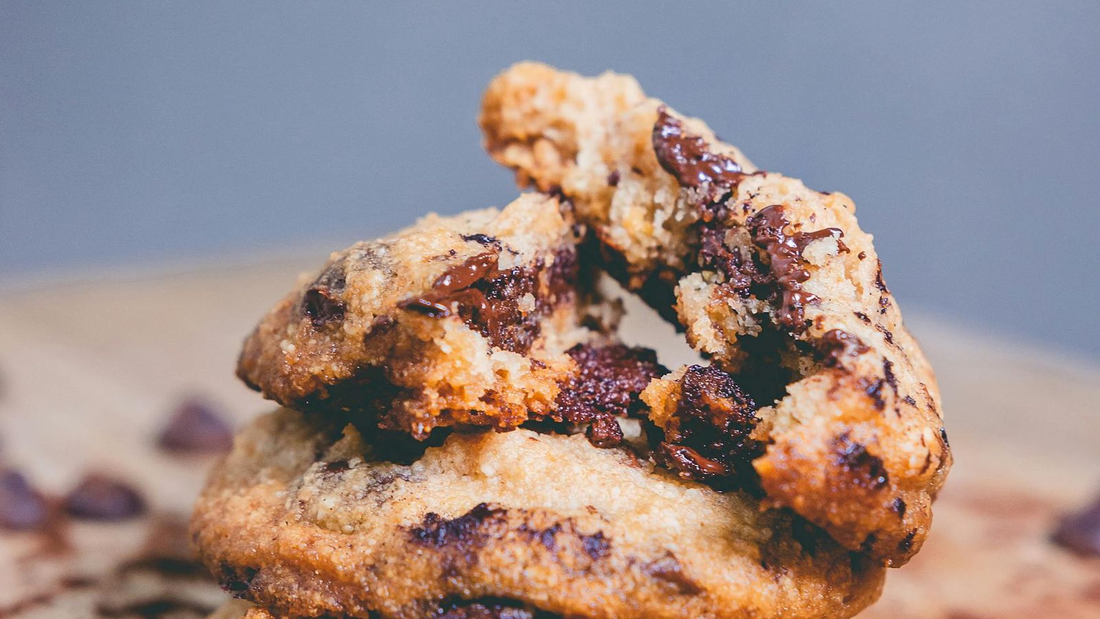 Close-up pile of chocolate chip cookies showing surface bake colour, chip distribution, and shape variation
