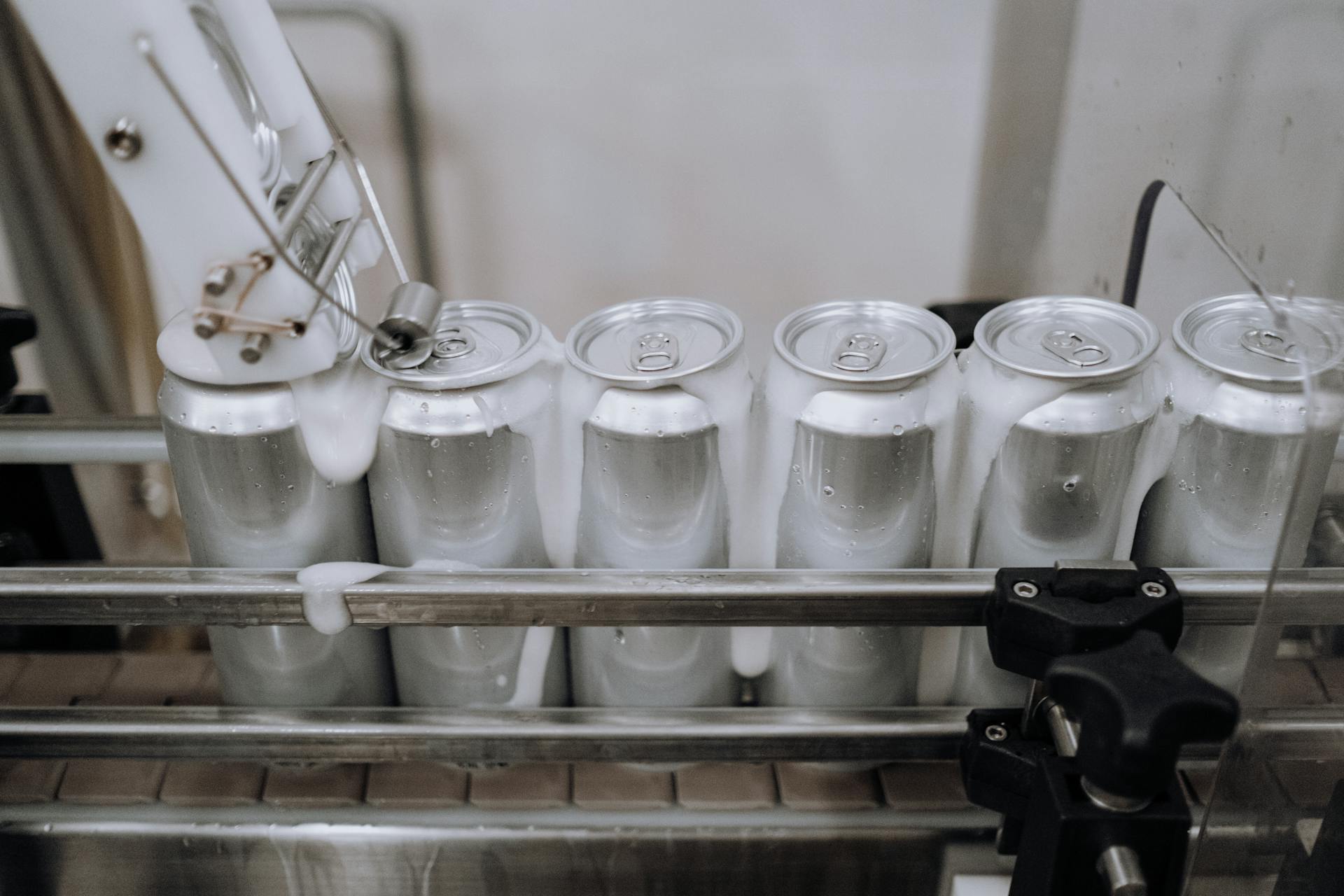 Lattine di alluminio riempite e tappate su una linea di produzione bevande