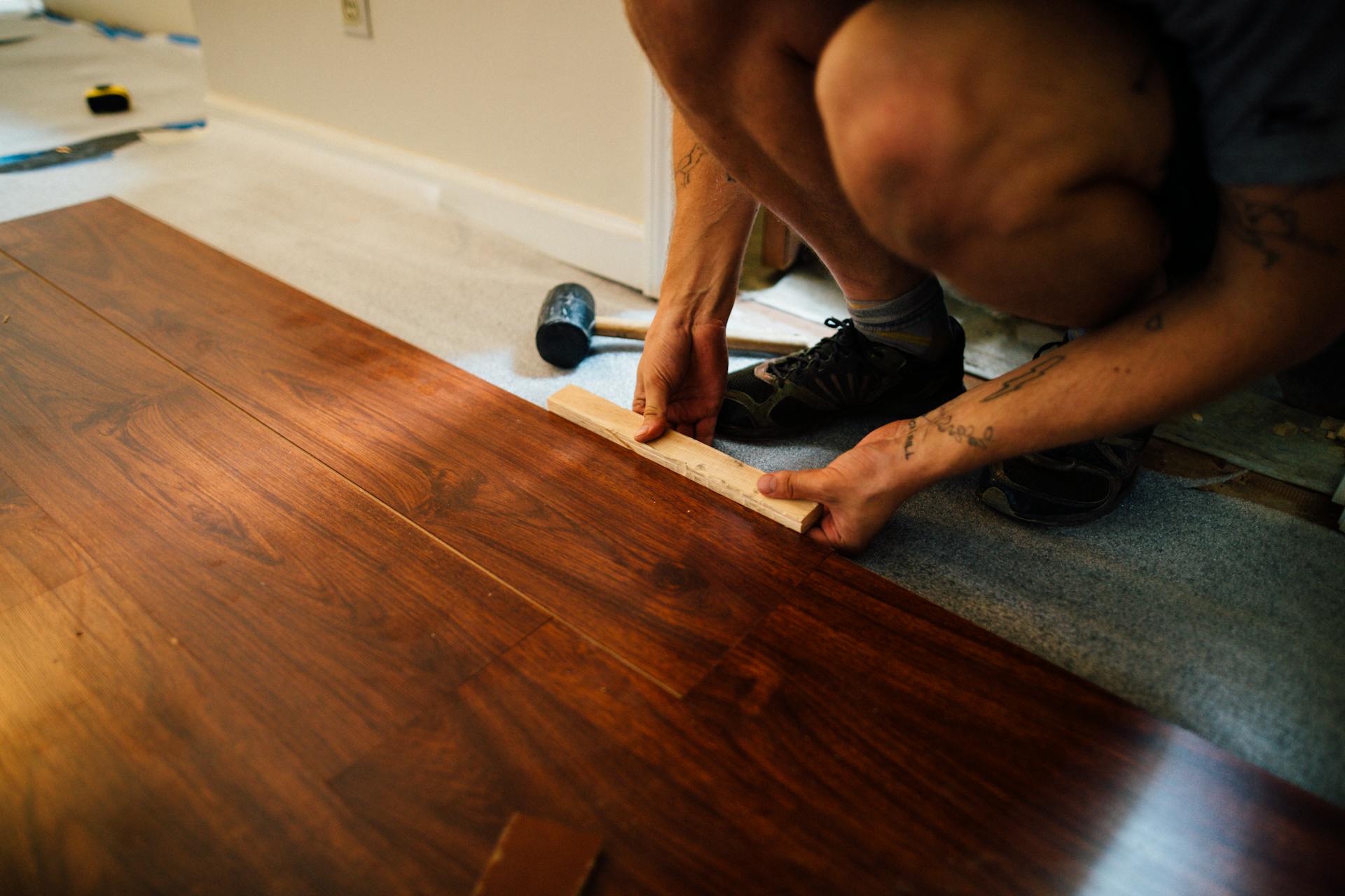 Installer fitting a wood-based panel against a finished wall surface