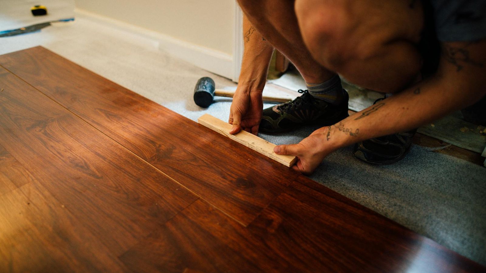 Installer fitting a wood-based panel against a finished wall surface