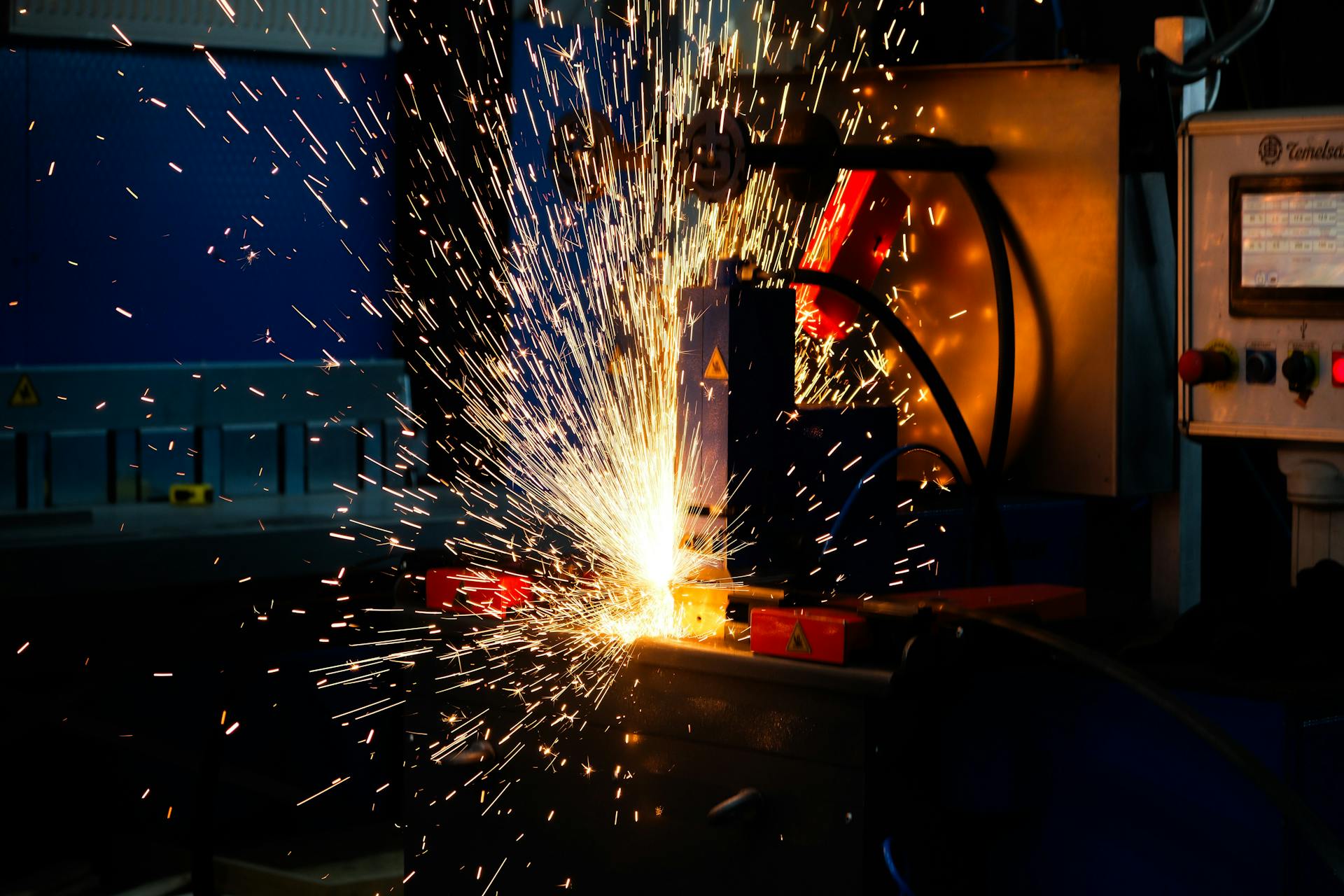 Forging press in operation showing sparks on a metalworking line