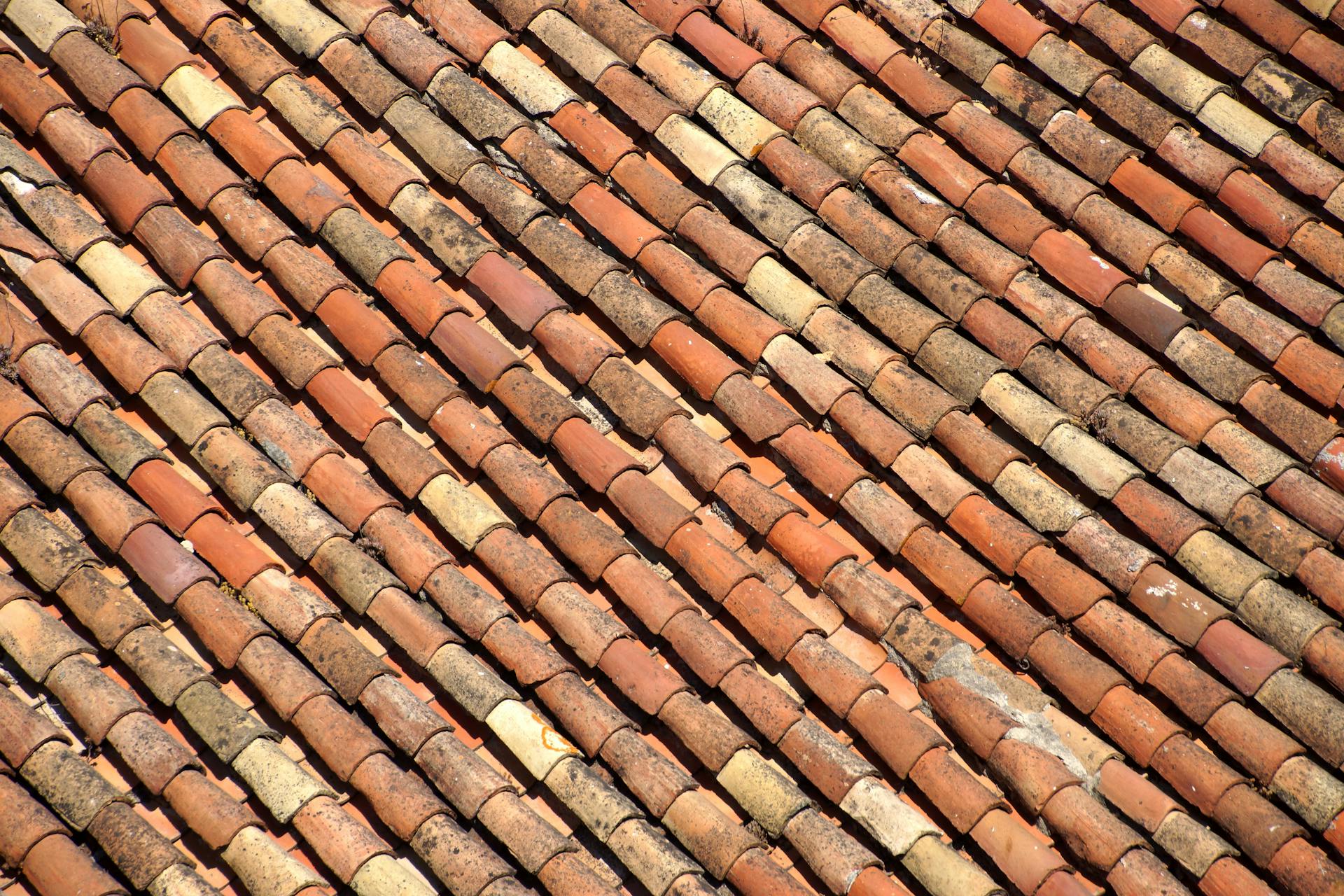Tuiles en terre cuite vieillies aux nuances alternées photographiées en motif diagonal