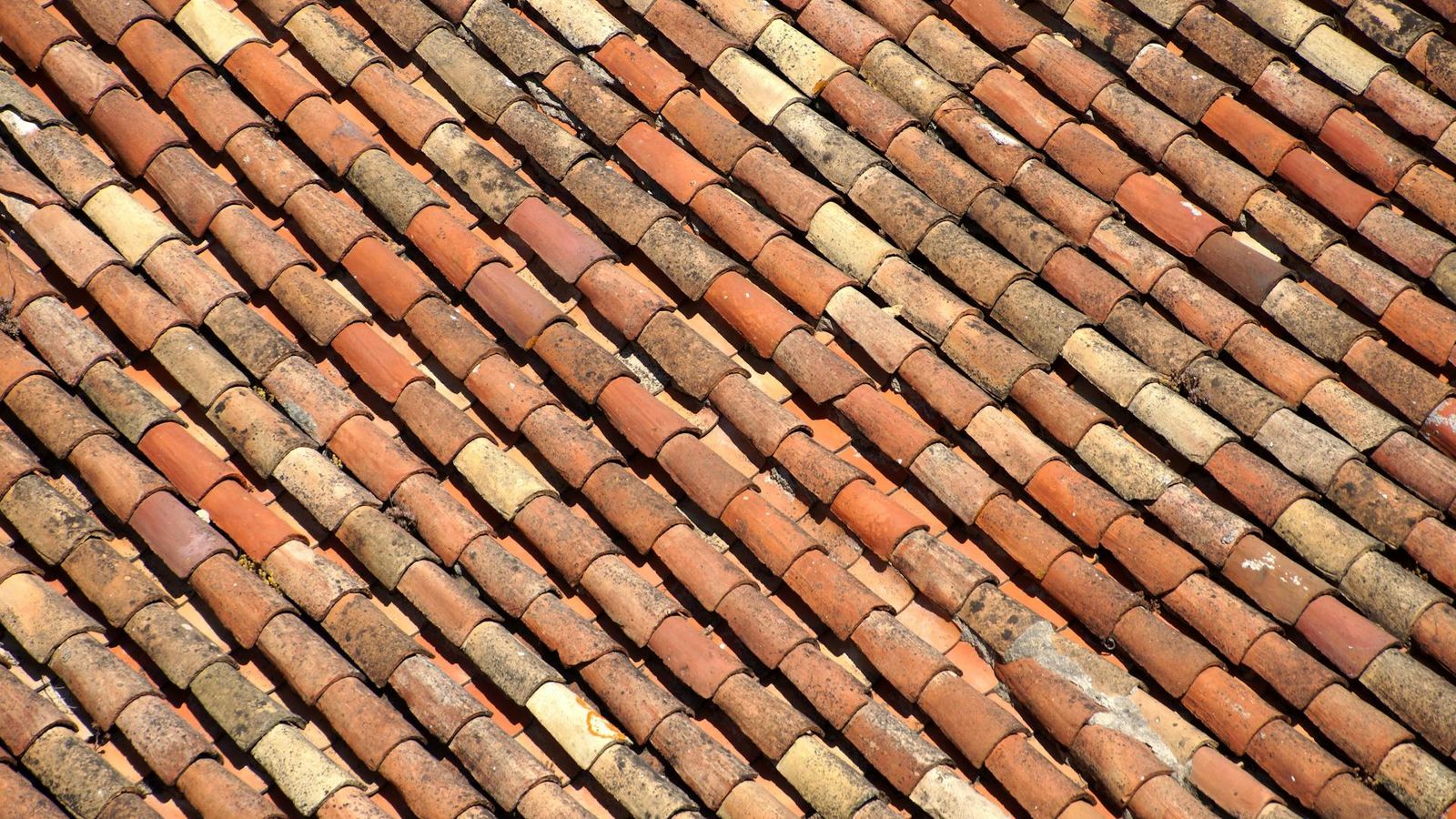 Tuiles en terre cuite vieillies aux nuances alternées photographiées en motif diagonal