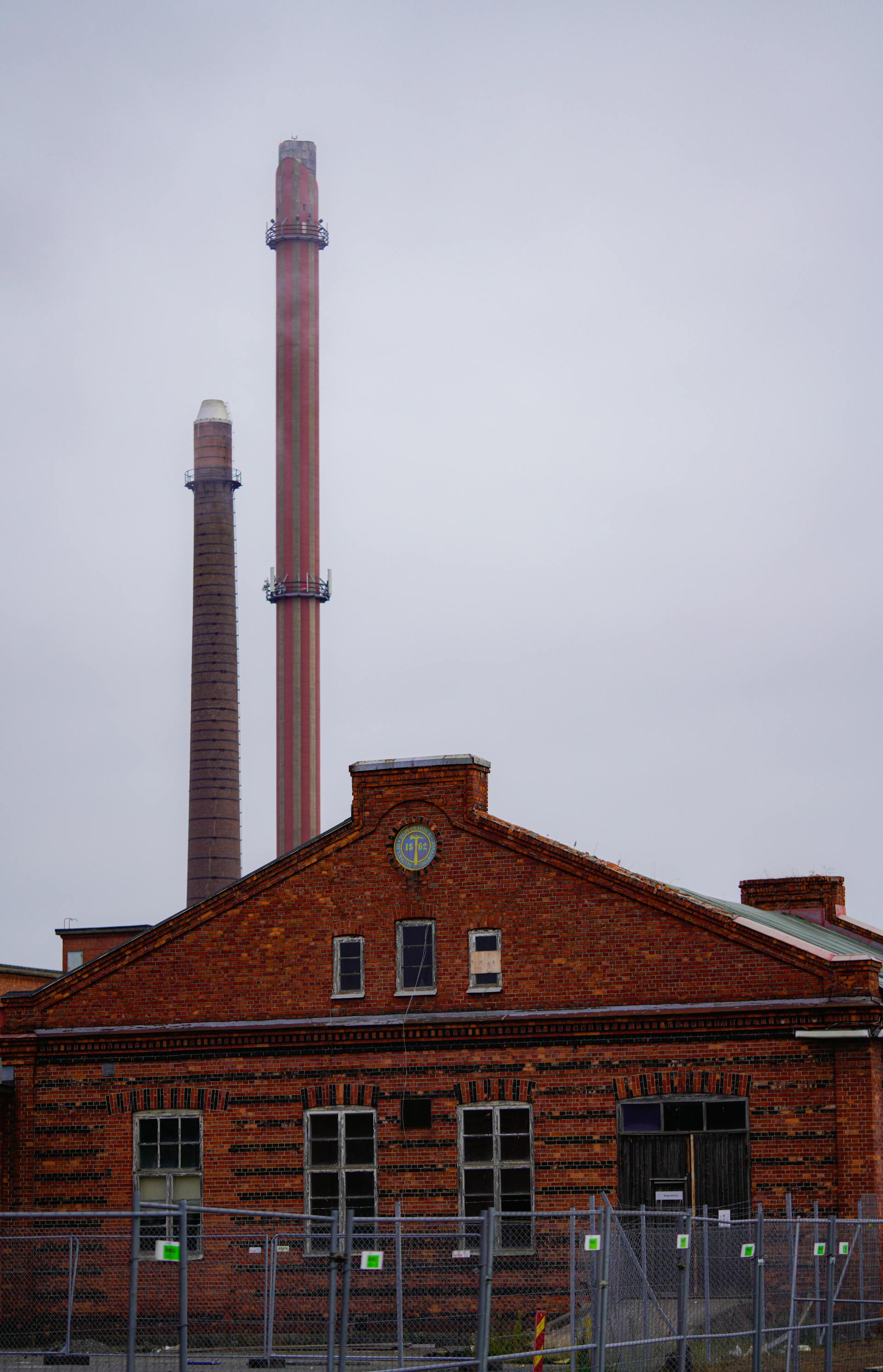 Antigua ladrillería industrial con dos chimeneas altas y hastial de ladrillo