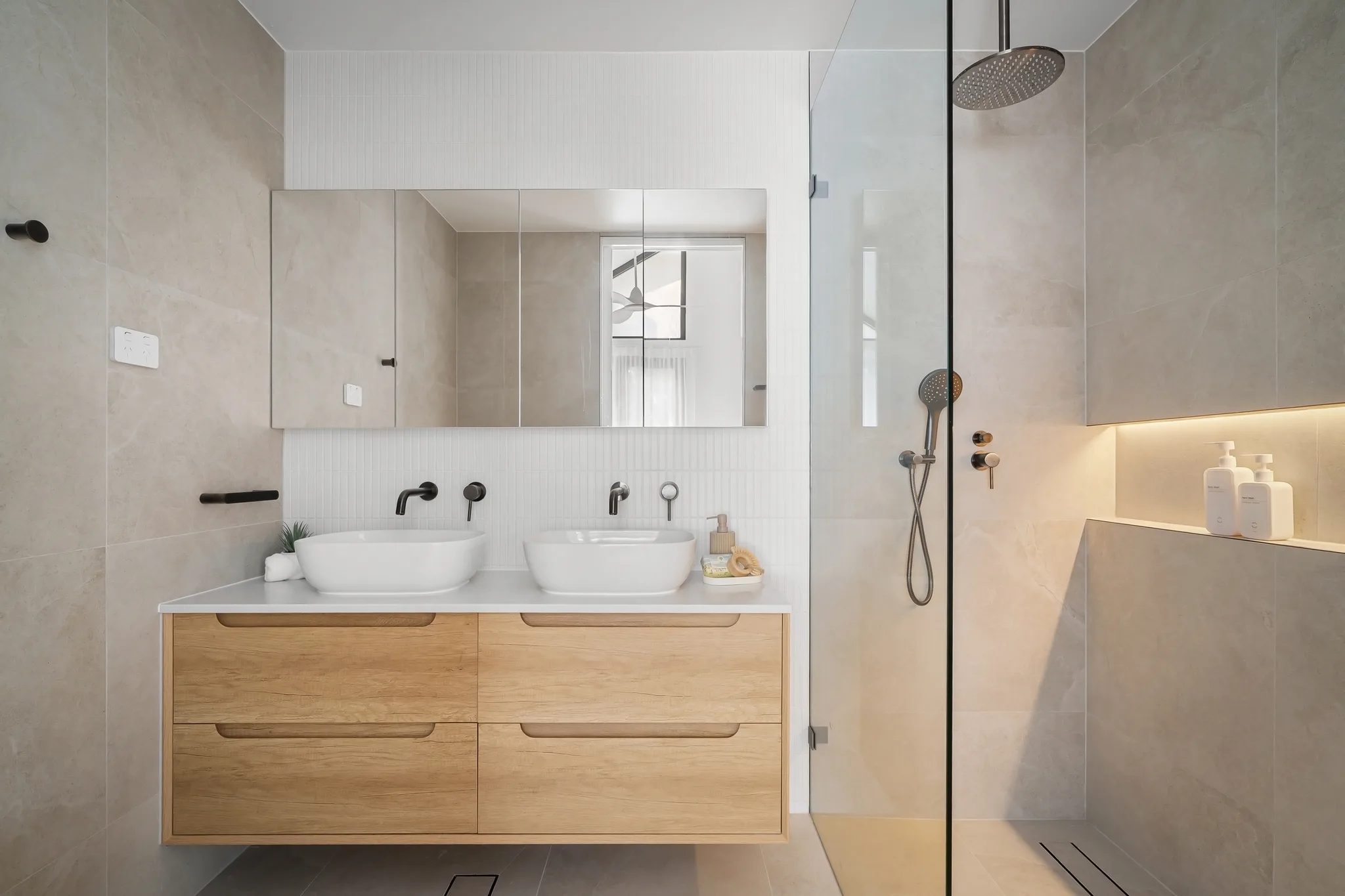 An AXIS bathroom in Chifley, a timber vanity with twin basins and a lit shower niche