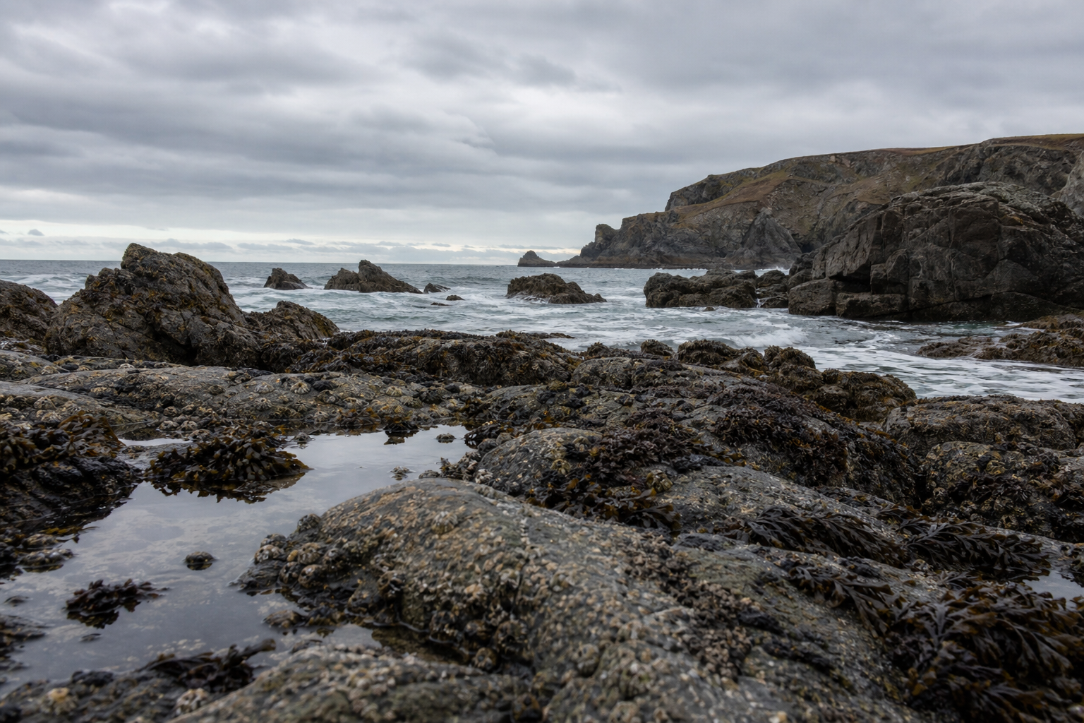 Rocky Cornwall coastline under overcast Atlantic sky with diffused coastal light