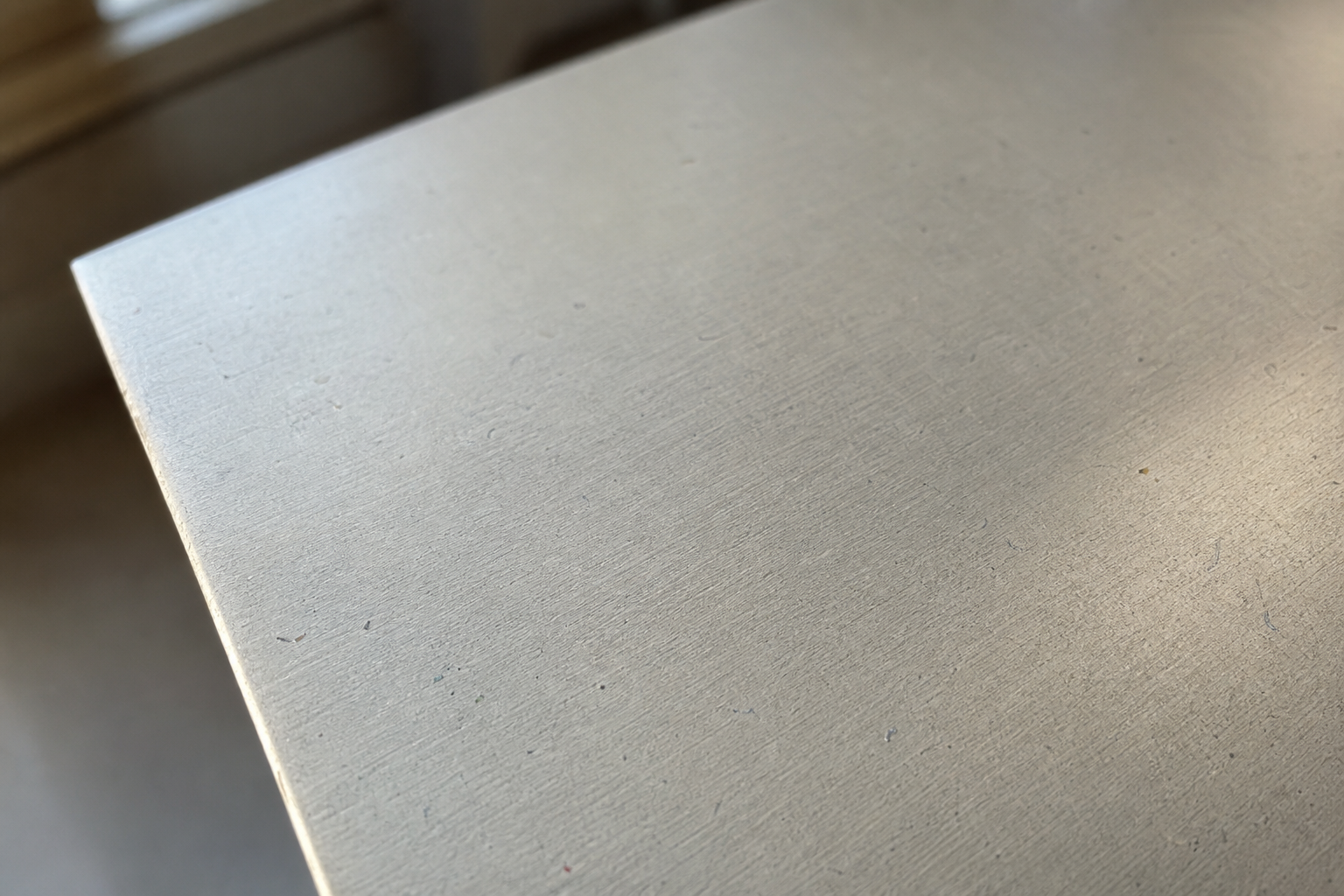 Close-up of a smooth aluminium painting panel surface with subtle texture