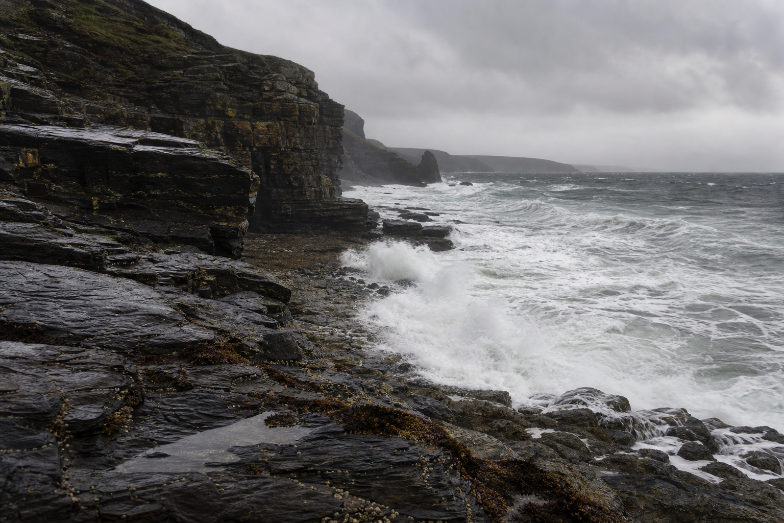 Rocky Atlantic-facing cliffs with breaking waves and overcast sky, Cornwall