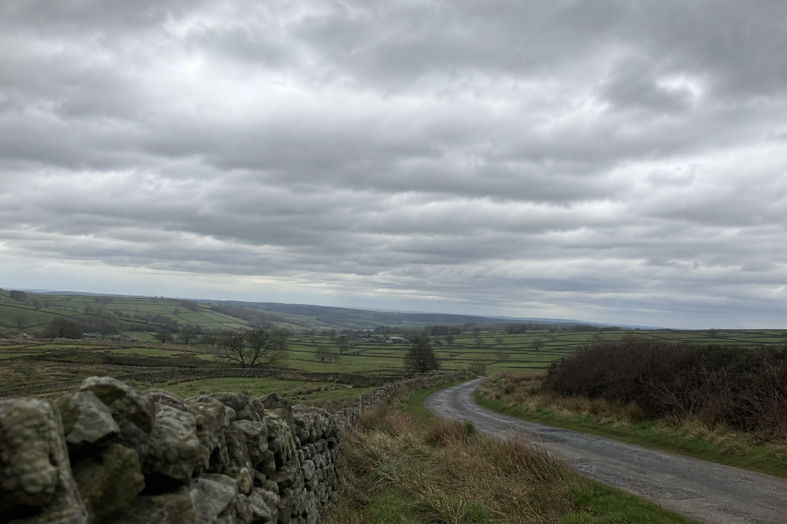 Low grey stratocumulus cloud layer spread across a wide British countryside horizon