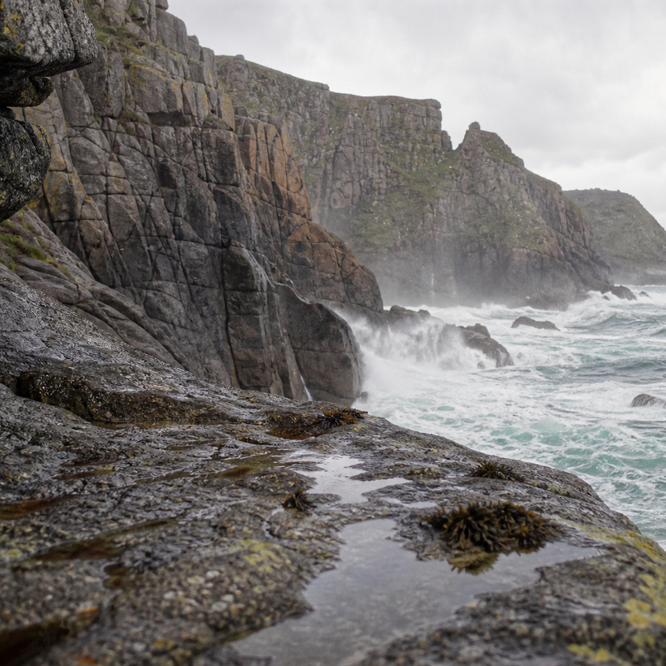 Rugged granite cliffs above Atlantic surf on a bright overcast day