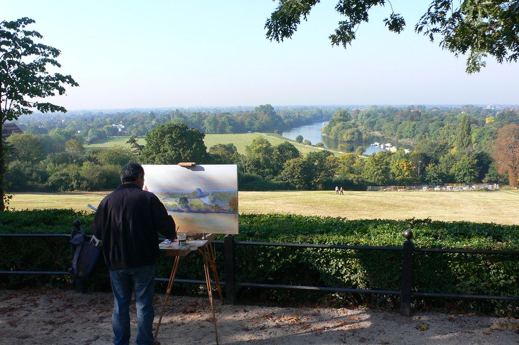 Artist painting an outdoor view of the River Thames and surrounding fields from Richmond Hill