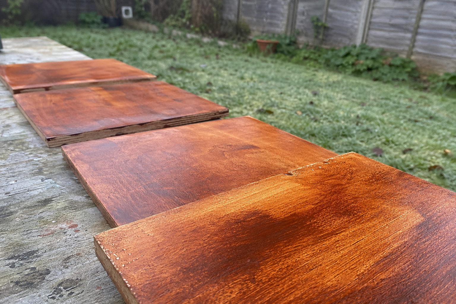 Several small wooden panels toned in warm burnt sienna laid on a flat surface