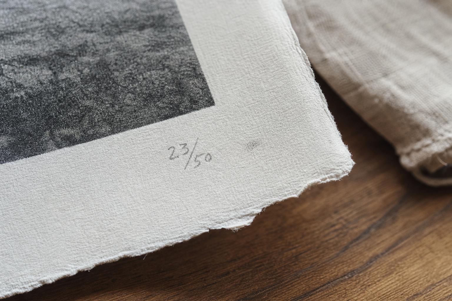 Corner of a fine art print showing pencilled edition number on thick cotton rag paper