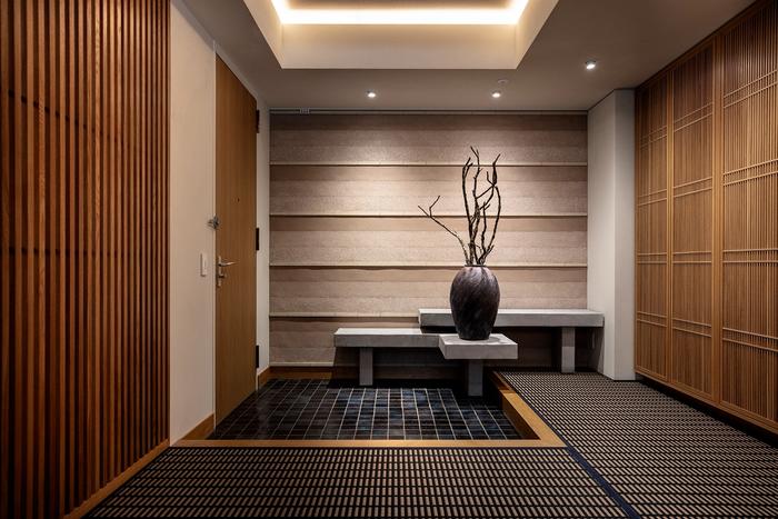 Entrance with woodnotes rug, indigo tiles, custom casework and rammed earth wall