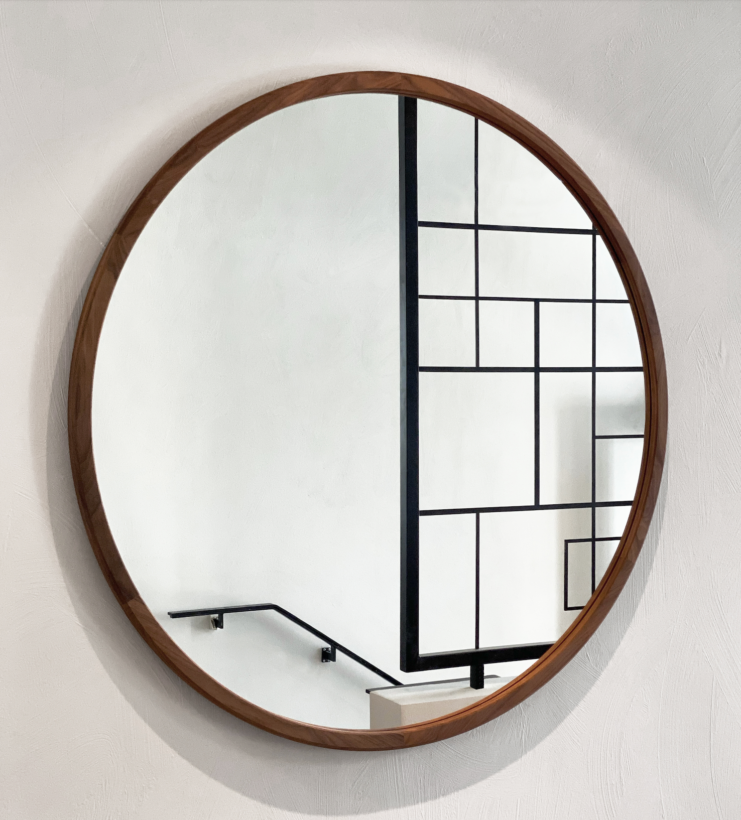Round Silhouette mirror with walnut frame from Frederica Furniture