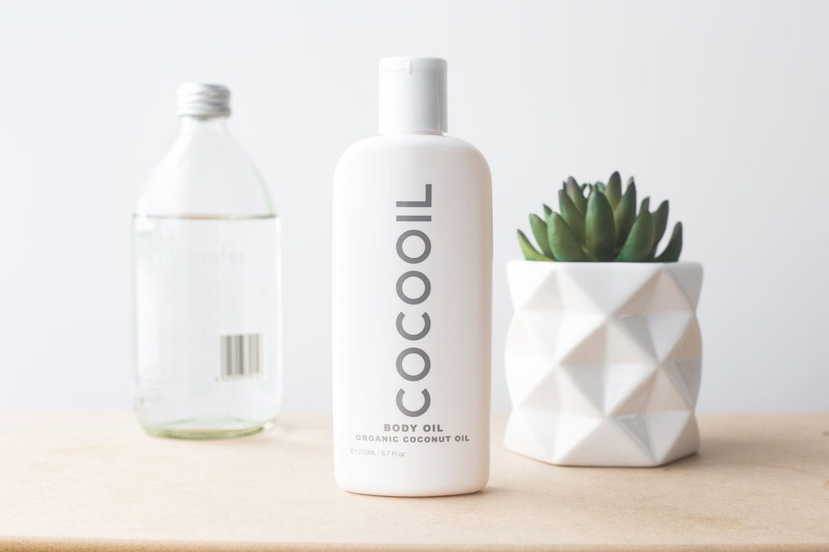 Coconut oil in glass bottles with raw brown kraft paper wrapping and clean stamp logos
