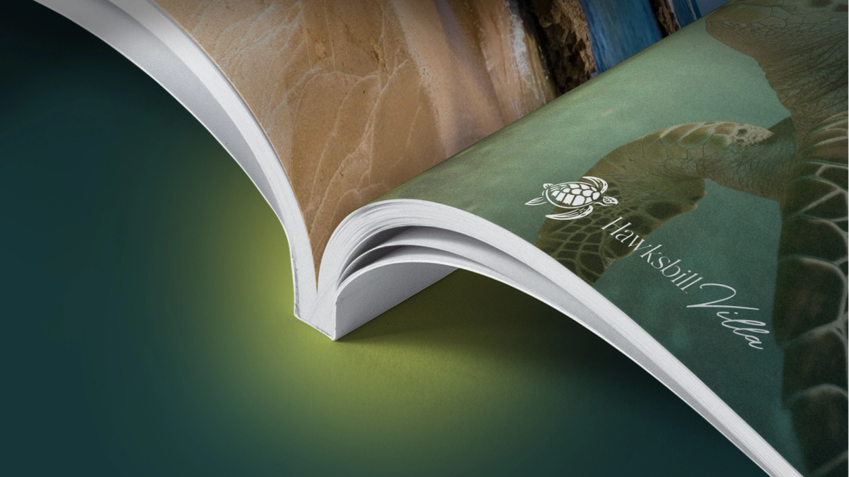Hawksbill Villa magazine mockup, curved cover with Hawksbill Villa horizontal logomark and beach photography