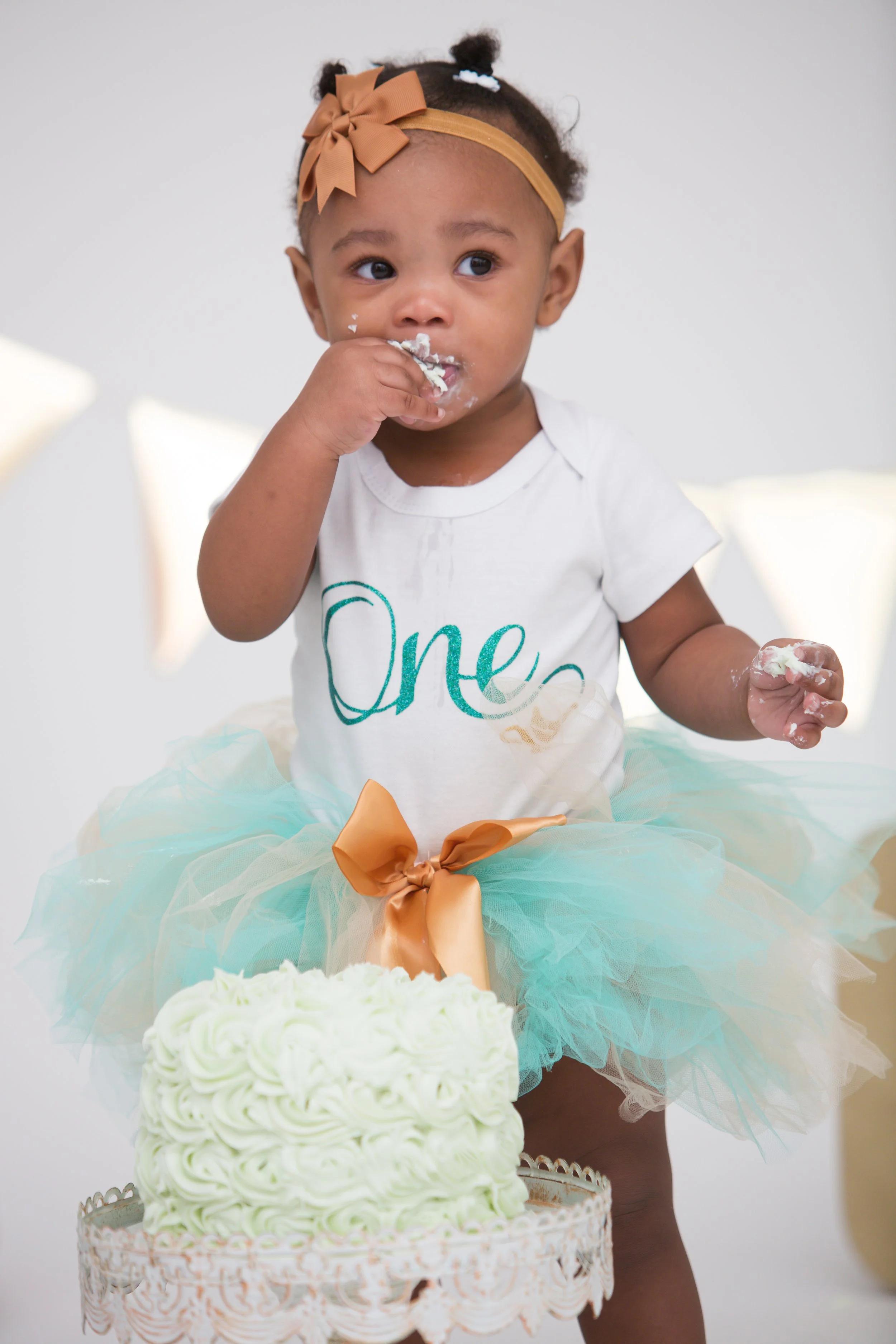 Black and white closeup of laughing baby with frosting all over mouth
