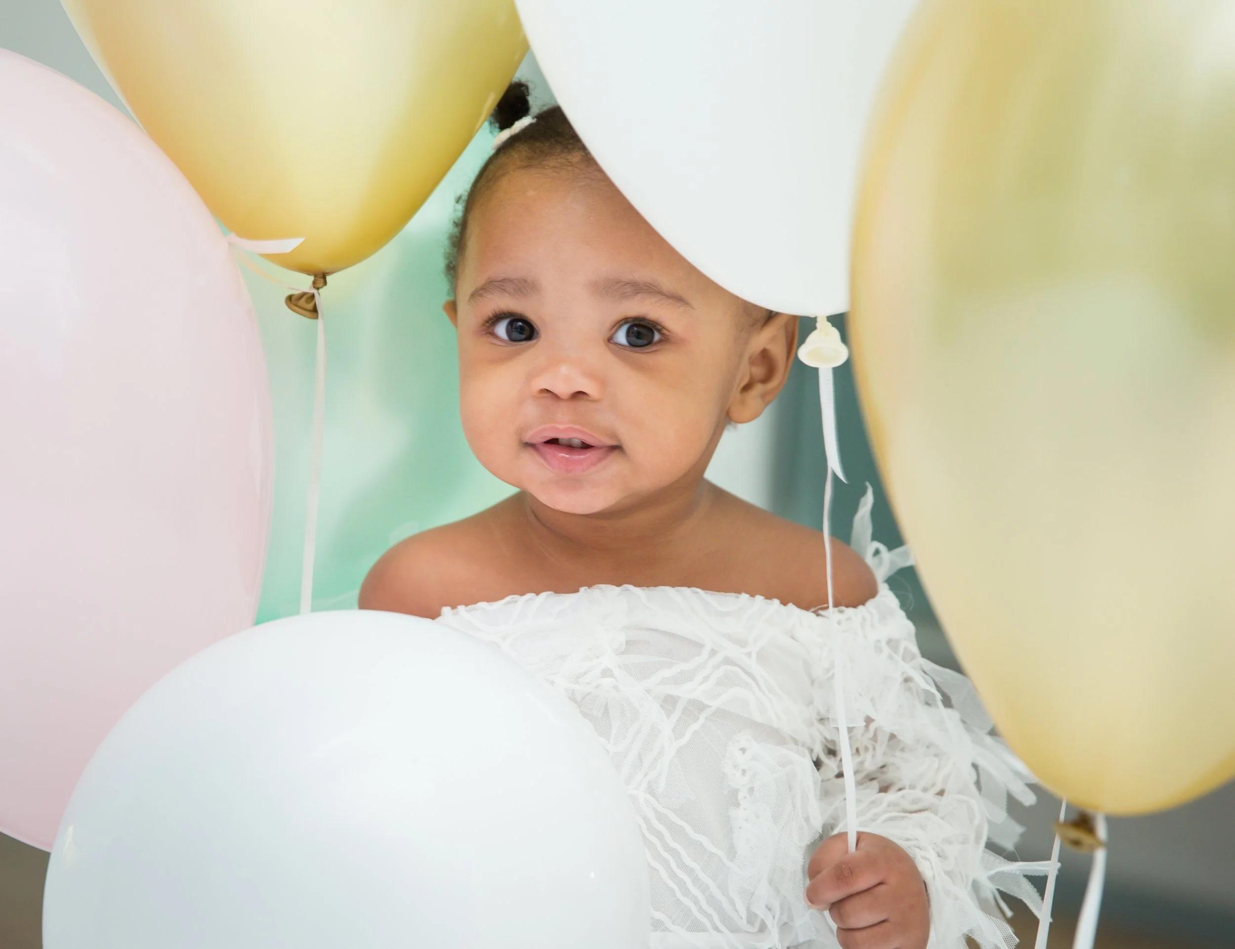 Baby girl in pink tutu with messy face eating birthday cake