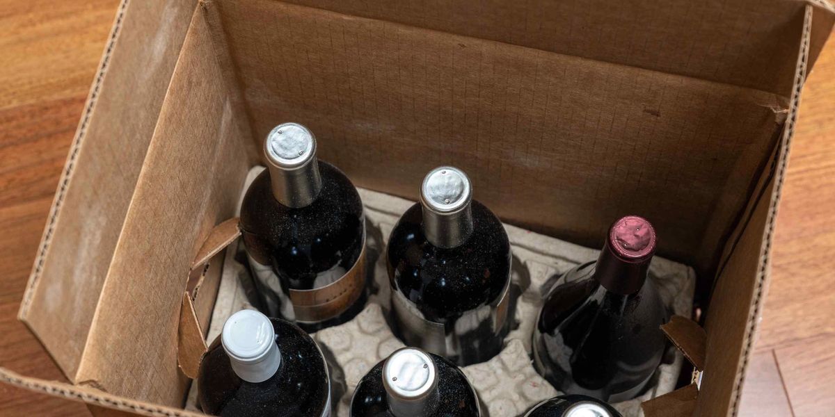 A shipping box containing six bottles of red wine.